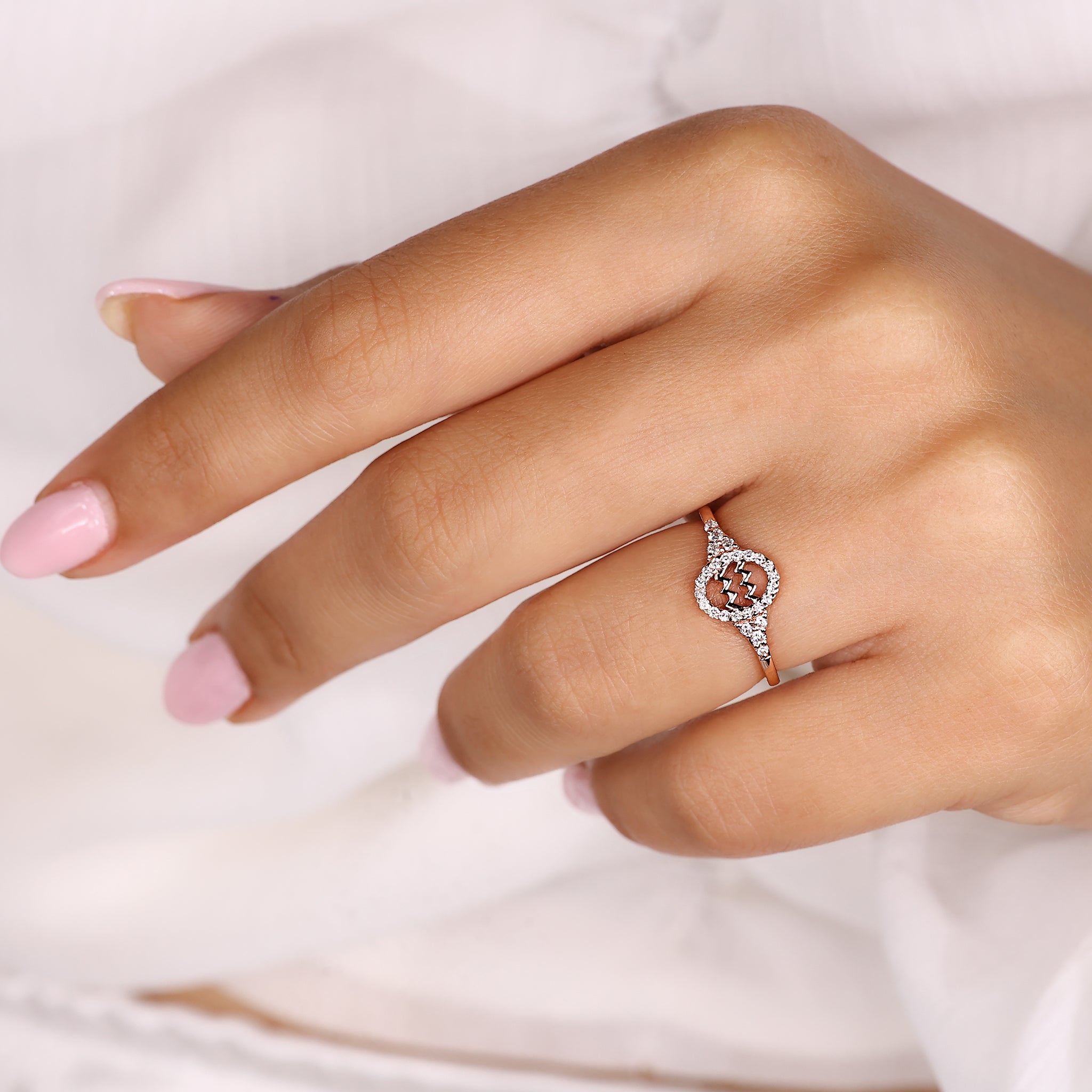 Aquarius engagement ring featuring round side stones and halo diamond design.
