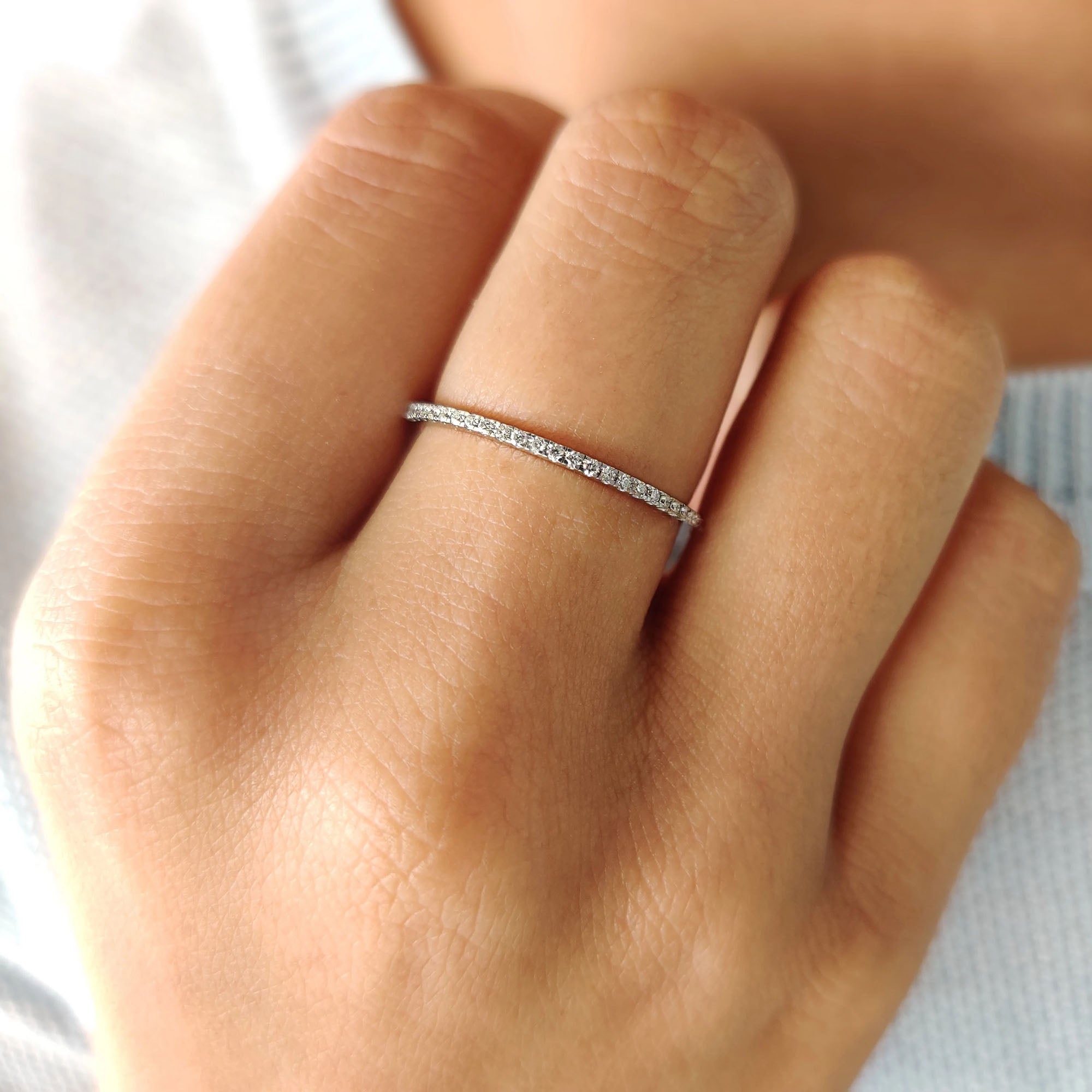 Half eternity band with sparkling round cut stones in a handcrafted design.

