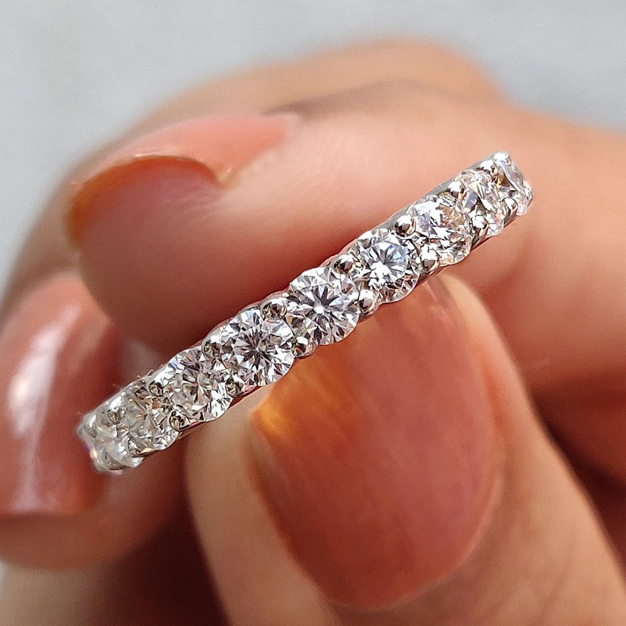 Moissanite eternity band white gold pairs perfectly with round cut wedding band.
