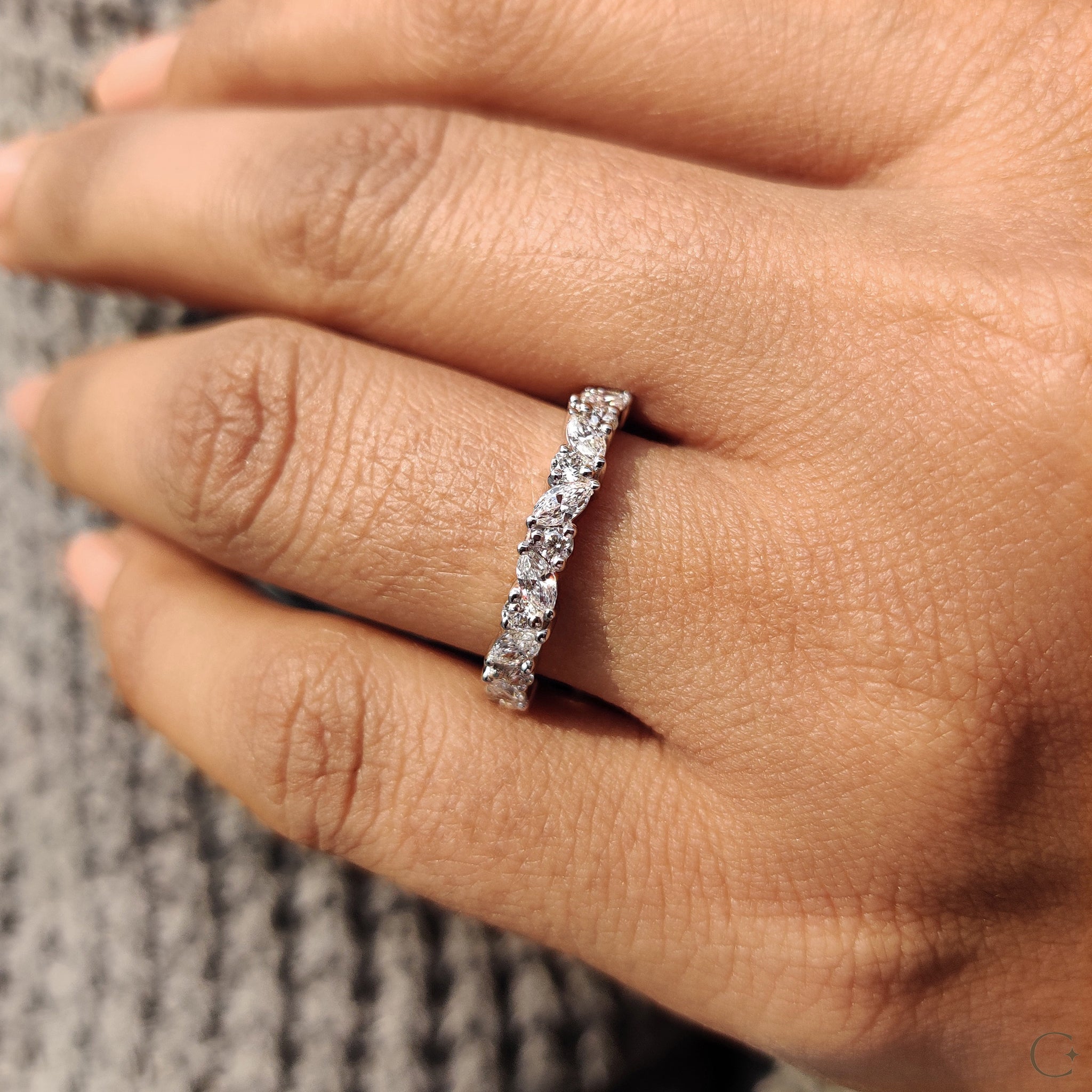 White gold band featuring round cut diamonds.
