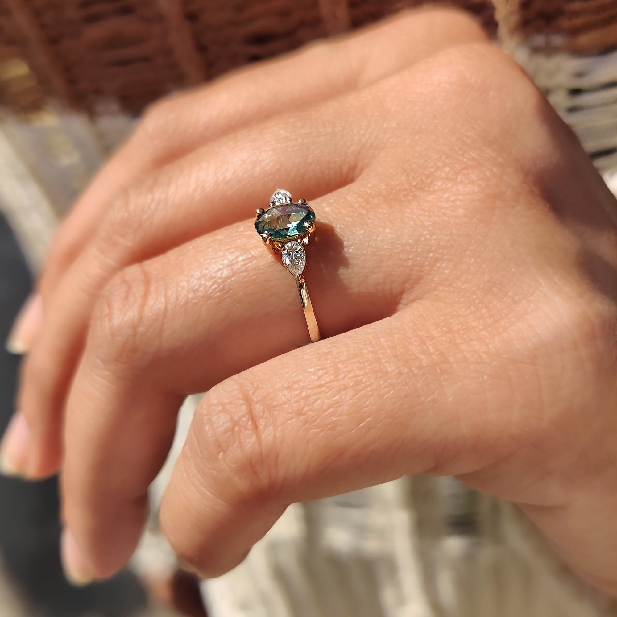 Moissanite engagement ring with four prong setting and pear side stones