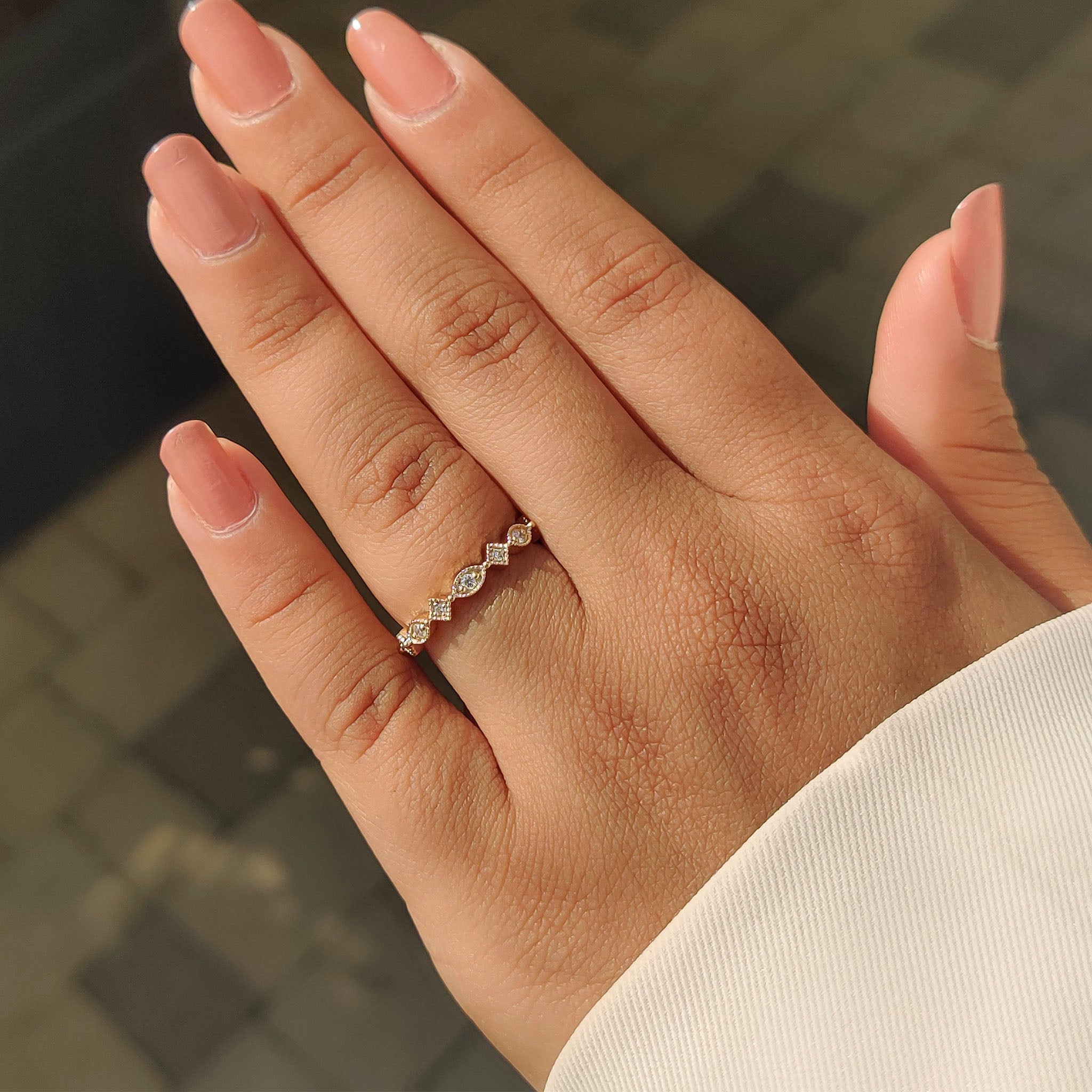 Round cut diamond wedding band with marquise outline and yellow gold finish.
