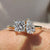 "A Toi Et Moi engagement ring featuring a princess cut diamond and a pear cut diamond, set in a yellow gold band with a prong setting.
