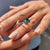 Best place to buy an engagement ring featuring green round Moissanite in a twisted rope rose gold band.

