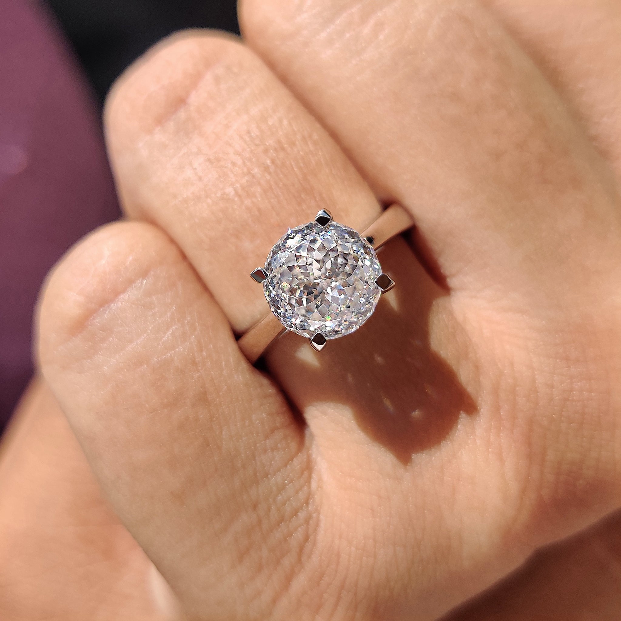 White gold solitaire engagement ring shines with cool glow.