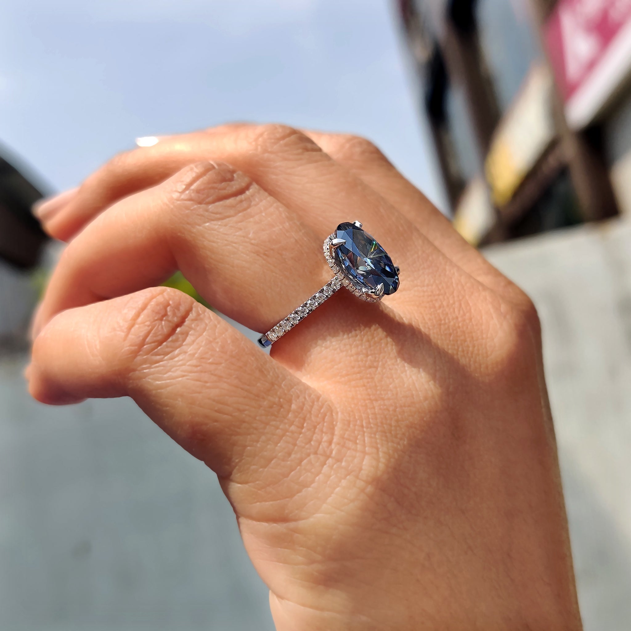 Women’s anniversary ring with royal dark blue oval cut Moissanite in a 4 claw prong setting and hidden halo.
