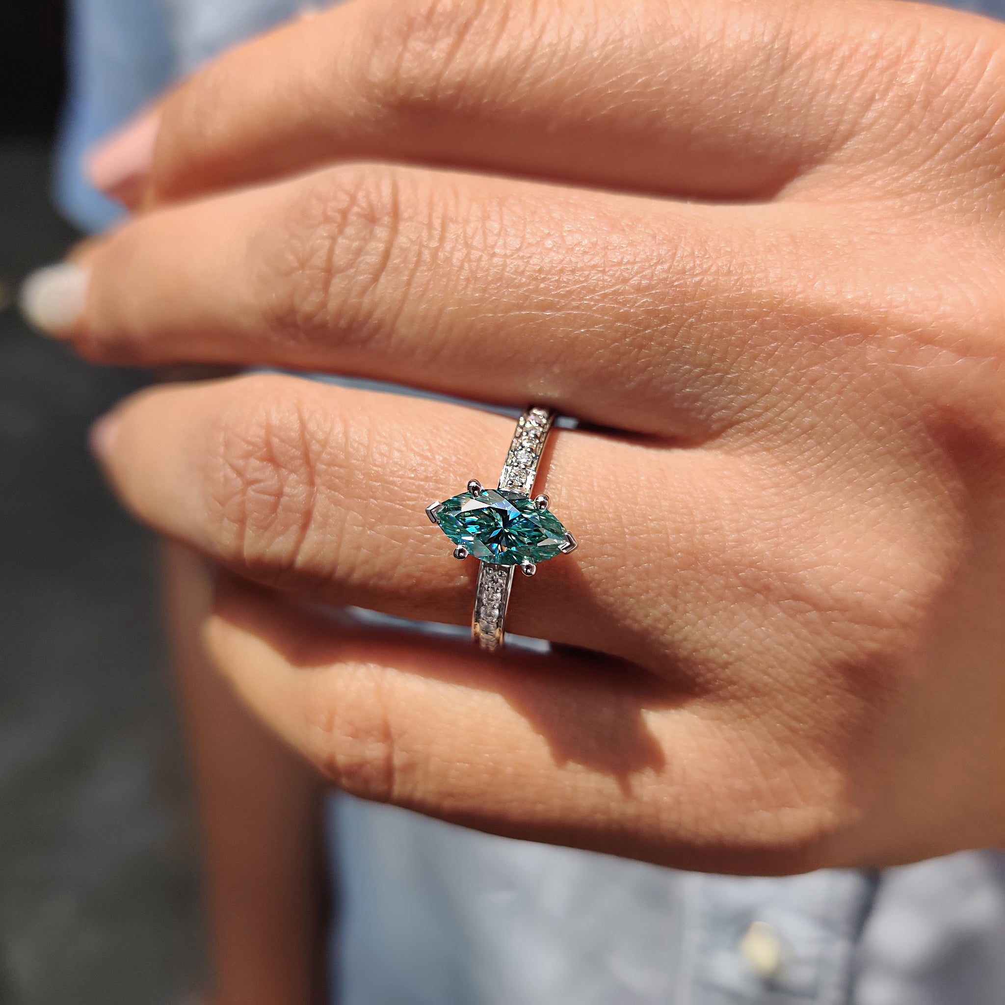 White gold engagement ring featuring a marquise moissanite center stone.