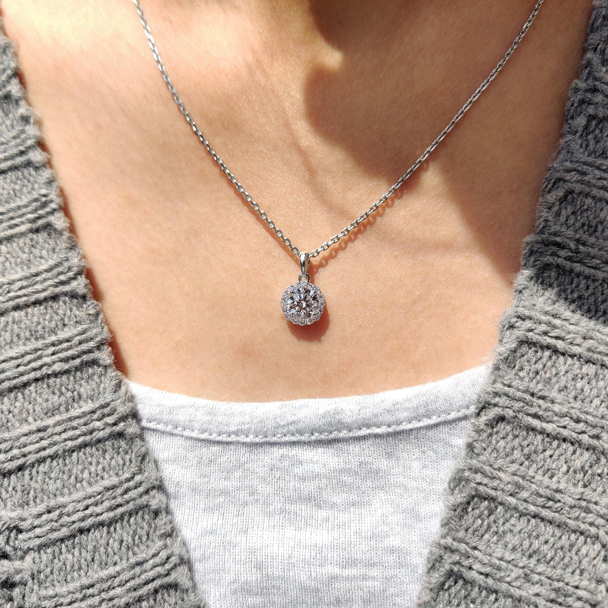 Round diamond halo pendant set in a white gold.
