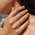 White gold wedding band with round cut moissanite, designed for everyday wear.