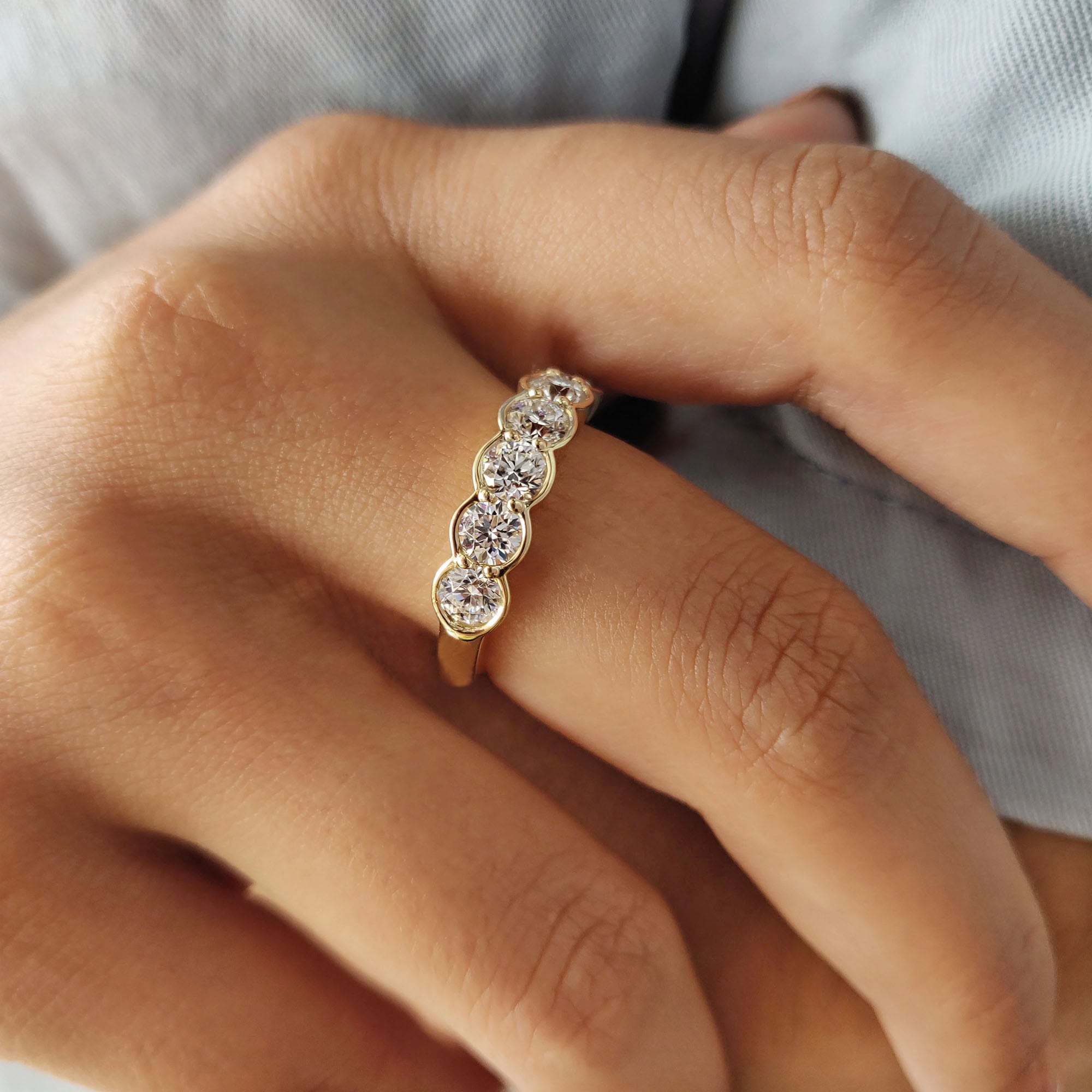 Yellow gold band with bezel setting and carat diamonds in a half eternity style.
