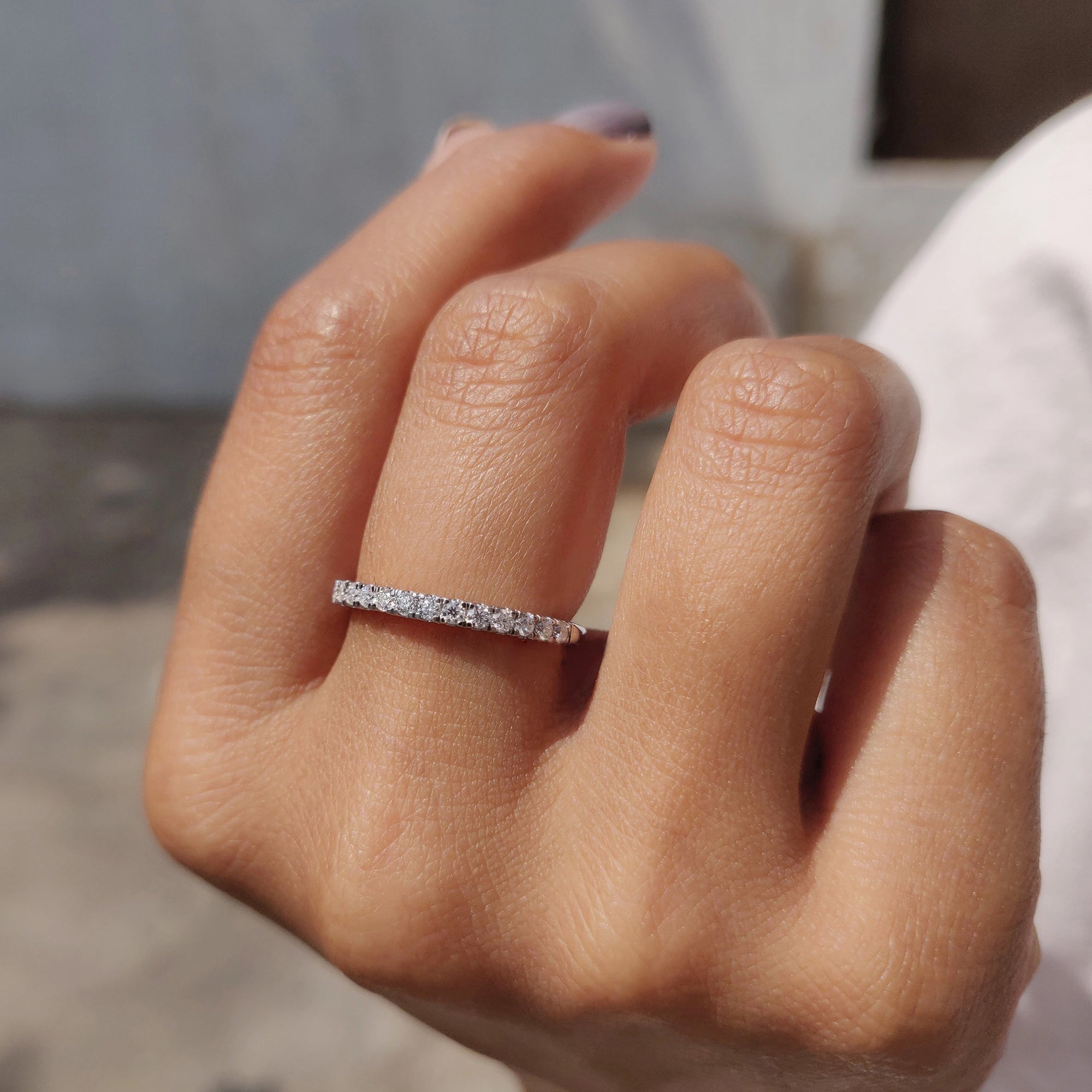 Handmade band highlights round moissanite wedding band.
