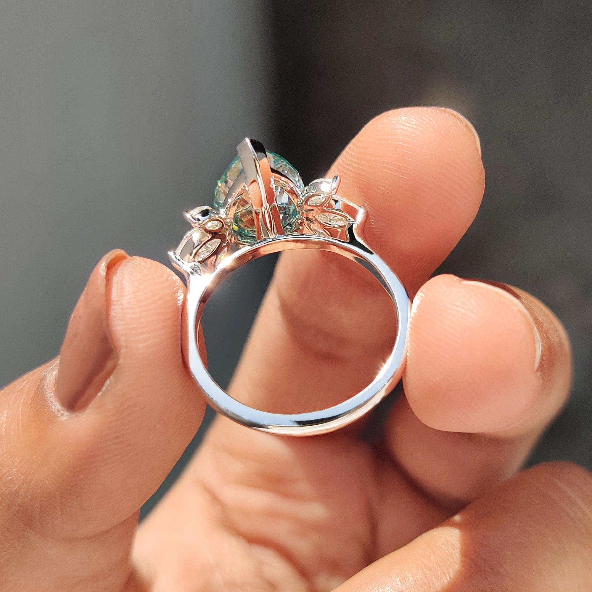 Moissanite engagement ring in a handmade jewelry design with elegant side stones.
