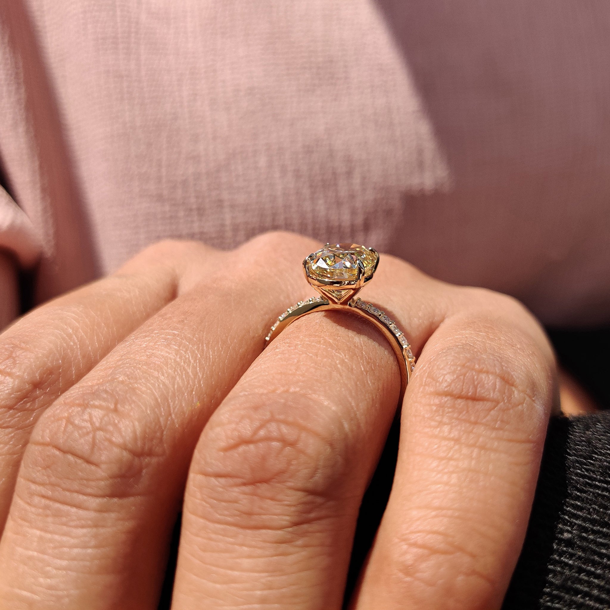 Round cut side stones complement the oval Moissanite center stone on this stunning engagement ring.