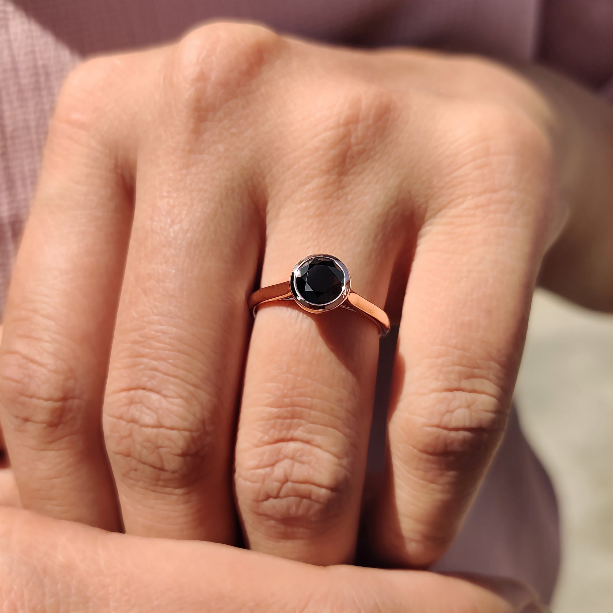 Custom engagement ring in a cathedral setting with a bold black round cut Moissanite.
