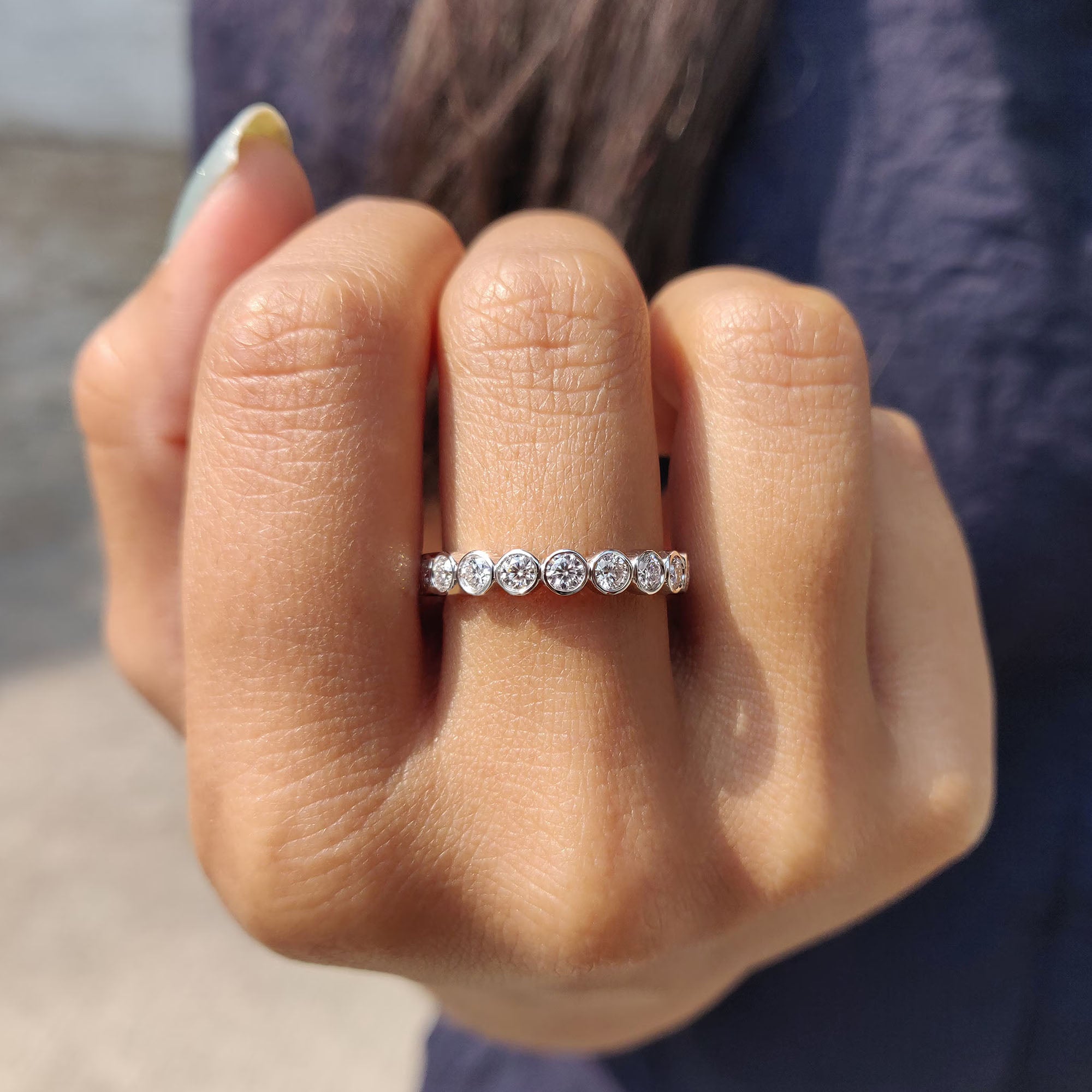 White gold wedding band featuring moissanite stones.
