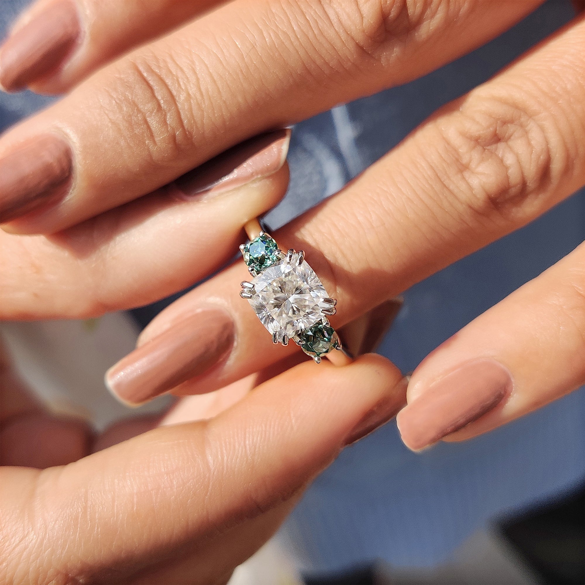 Elegant cushion cut Moissanite ring with two green side stones.
