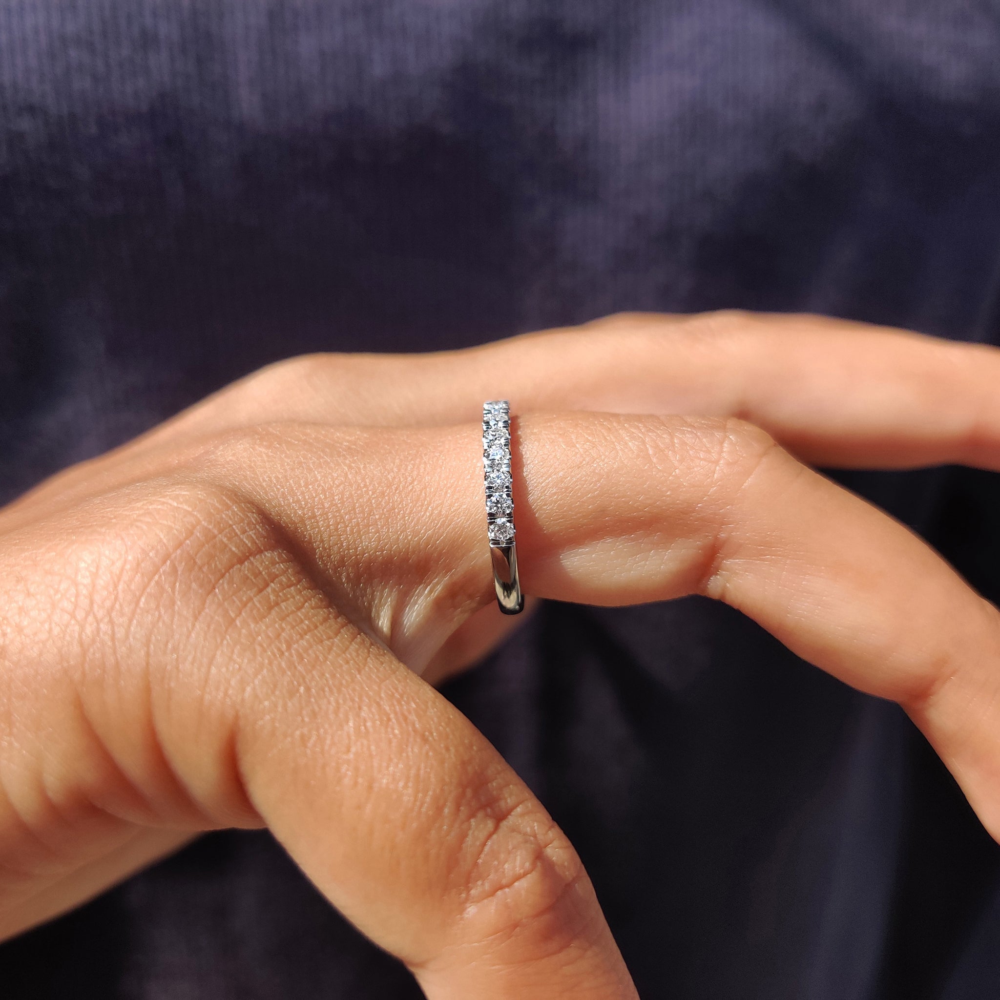 A unique Moissanite wedding band handcrafted for a personalized touch with round stones.