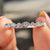 Half eternity wedding band designed with open back.