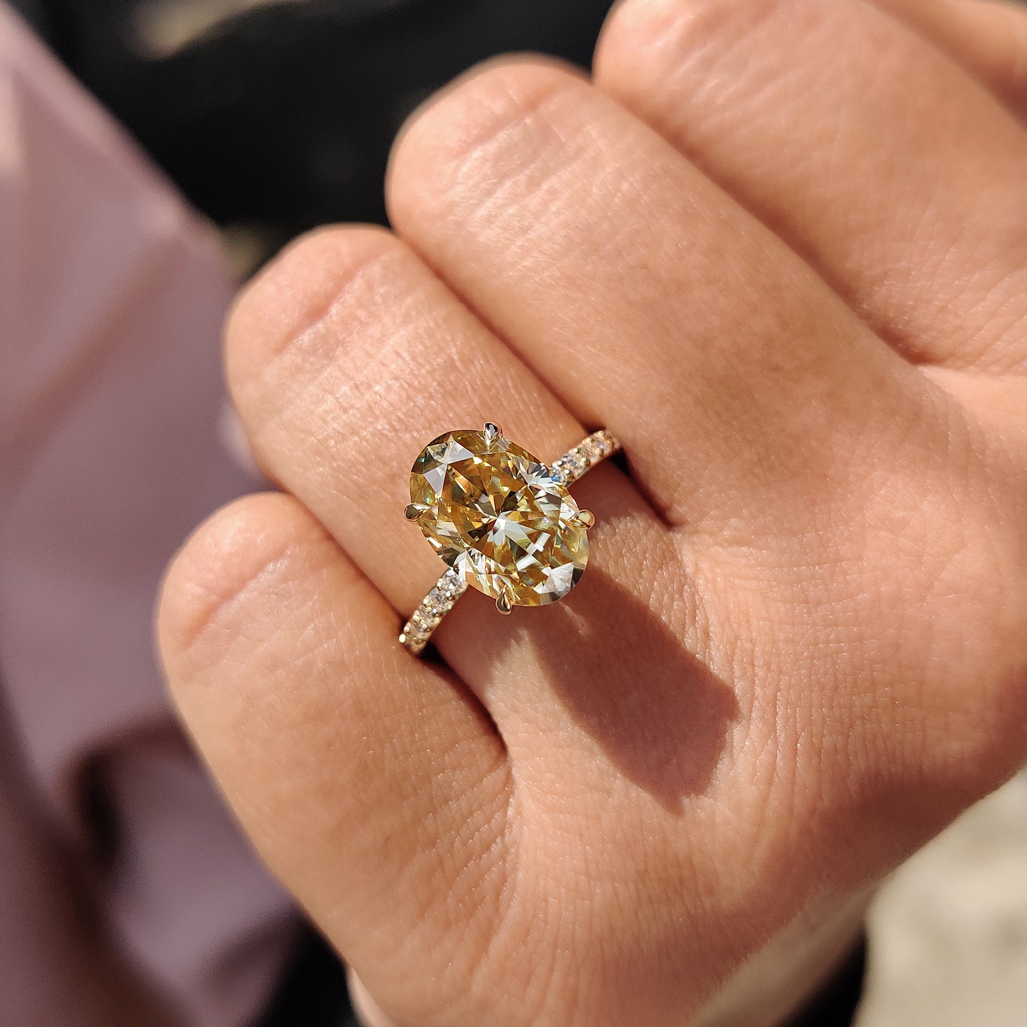 Oval and round cut Moissanite stones combine for a unique and modern engagement ring design.