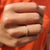 Dainty curved wedding band aligns with round moissanite wedding band.