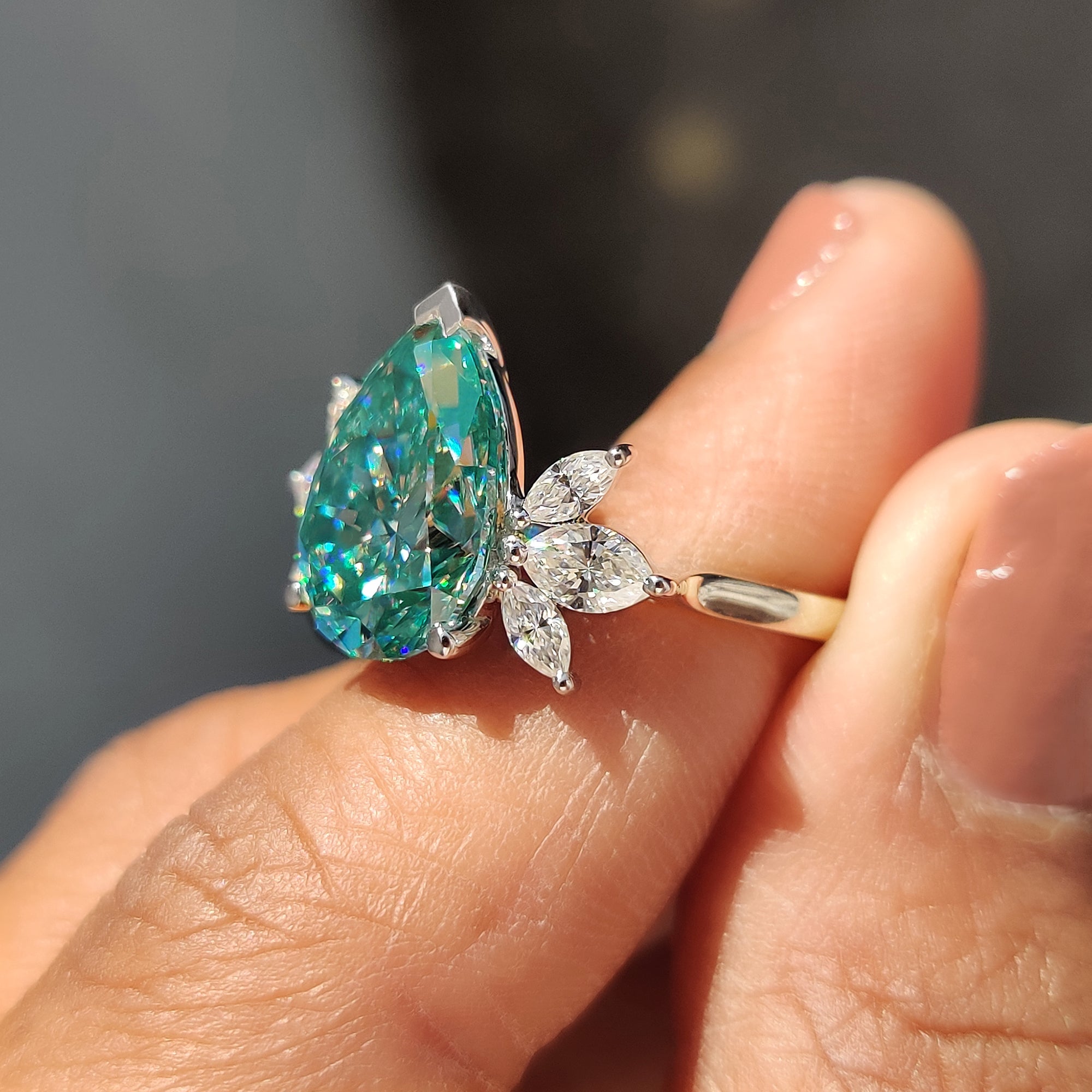 White gold engagement ring with pear cut cyan blue Moissanite for a bright, modern look.
