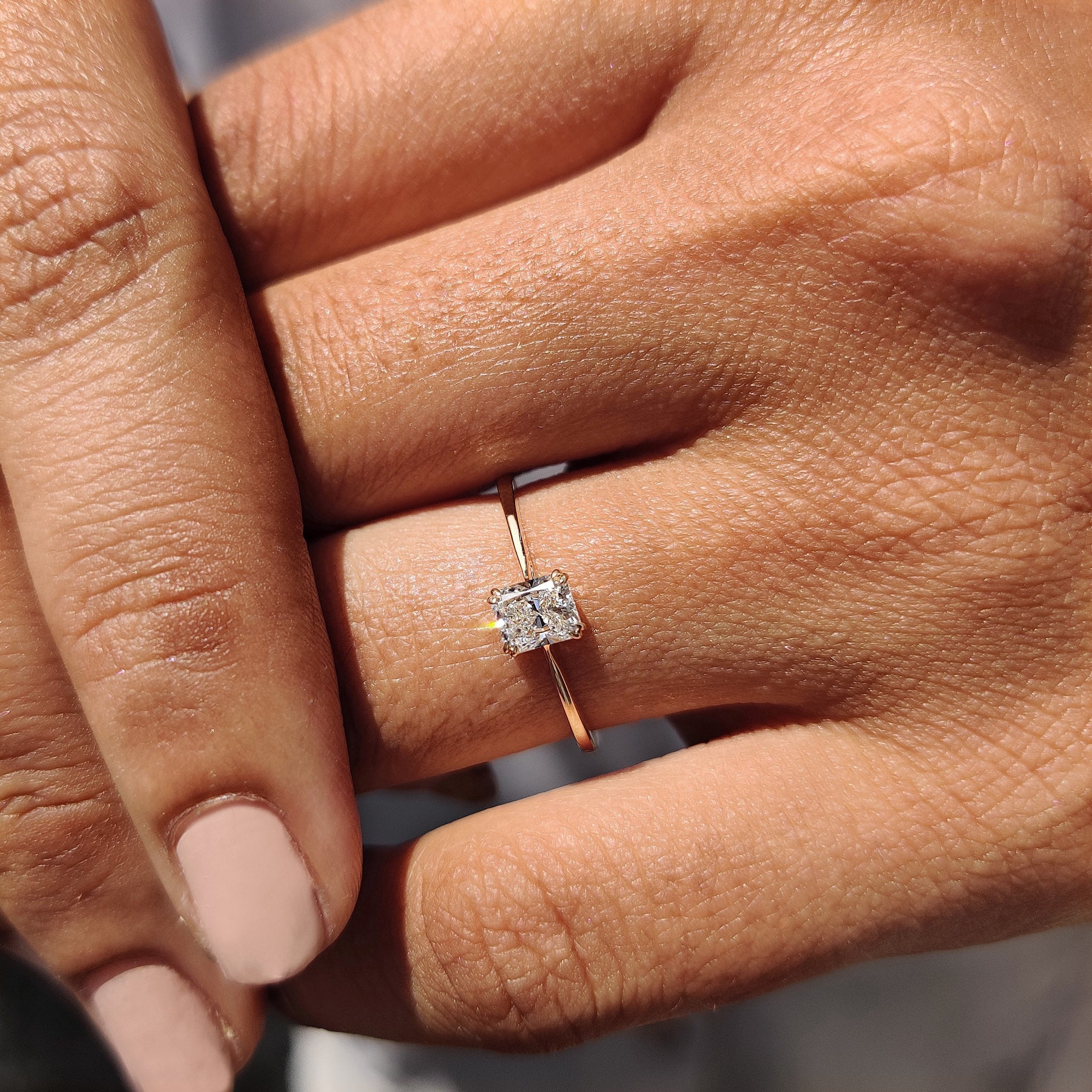 Carat Diamonds ring featuring a radiant cut diamond in gold.
