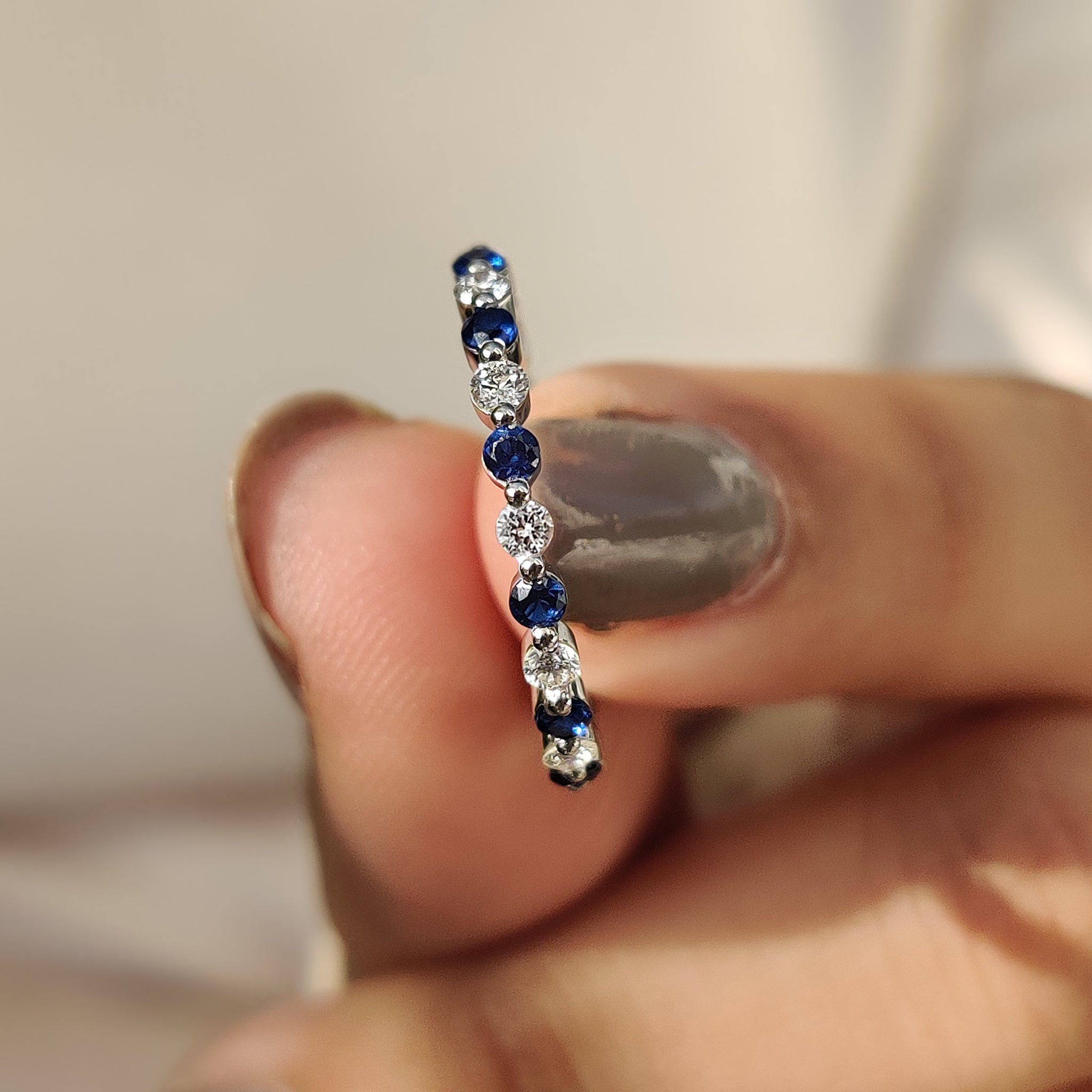 Blue diamond eternity band set in a sleek design for a modern wedding look.
