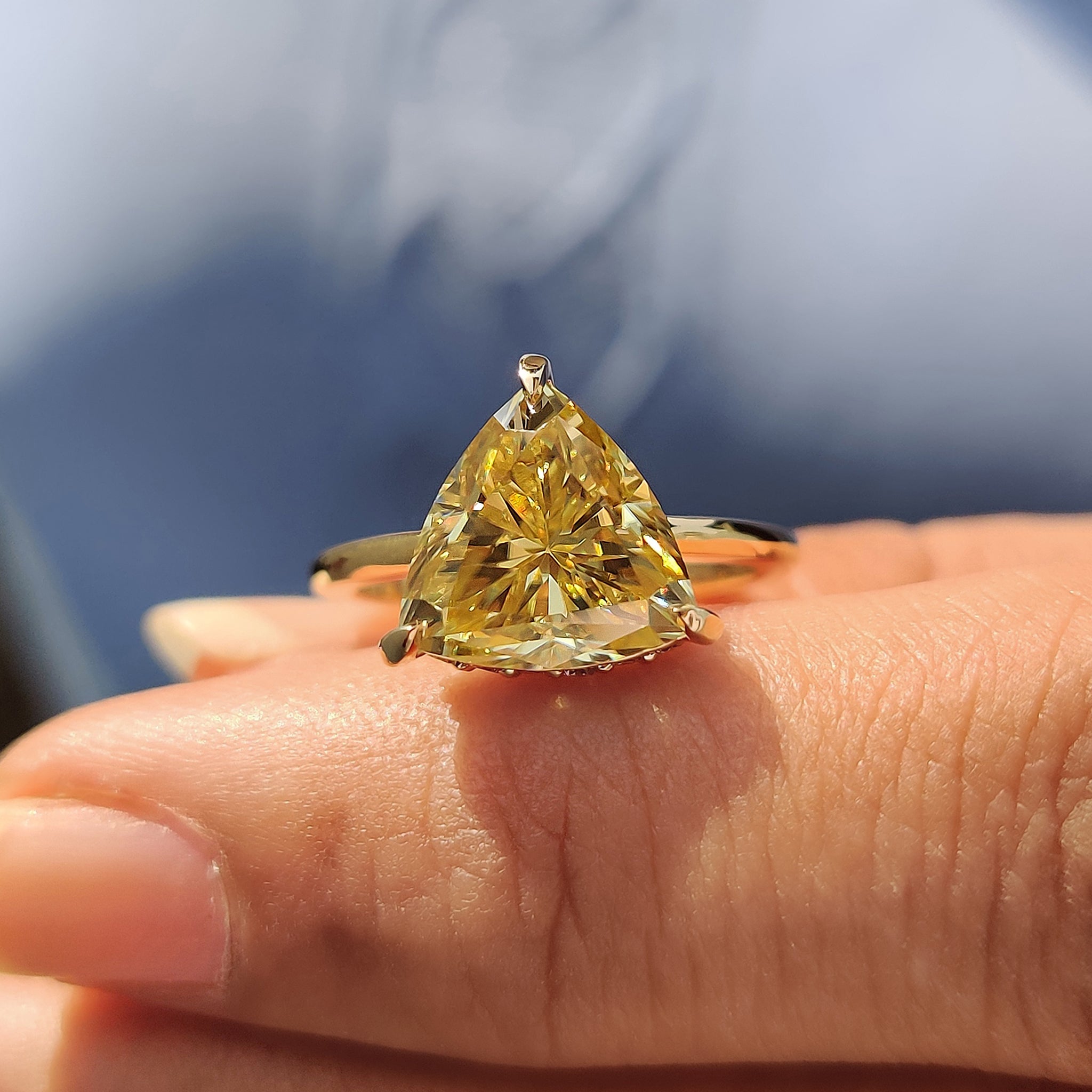 Solitaire setting with a canary yellow trillion cut moissanite engagement ring.