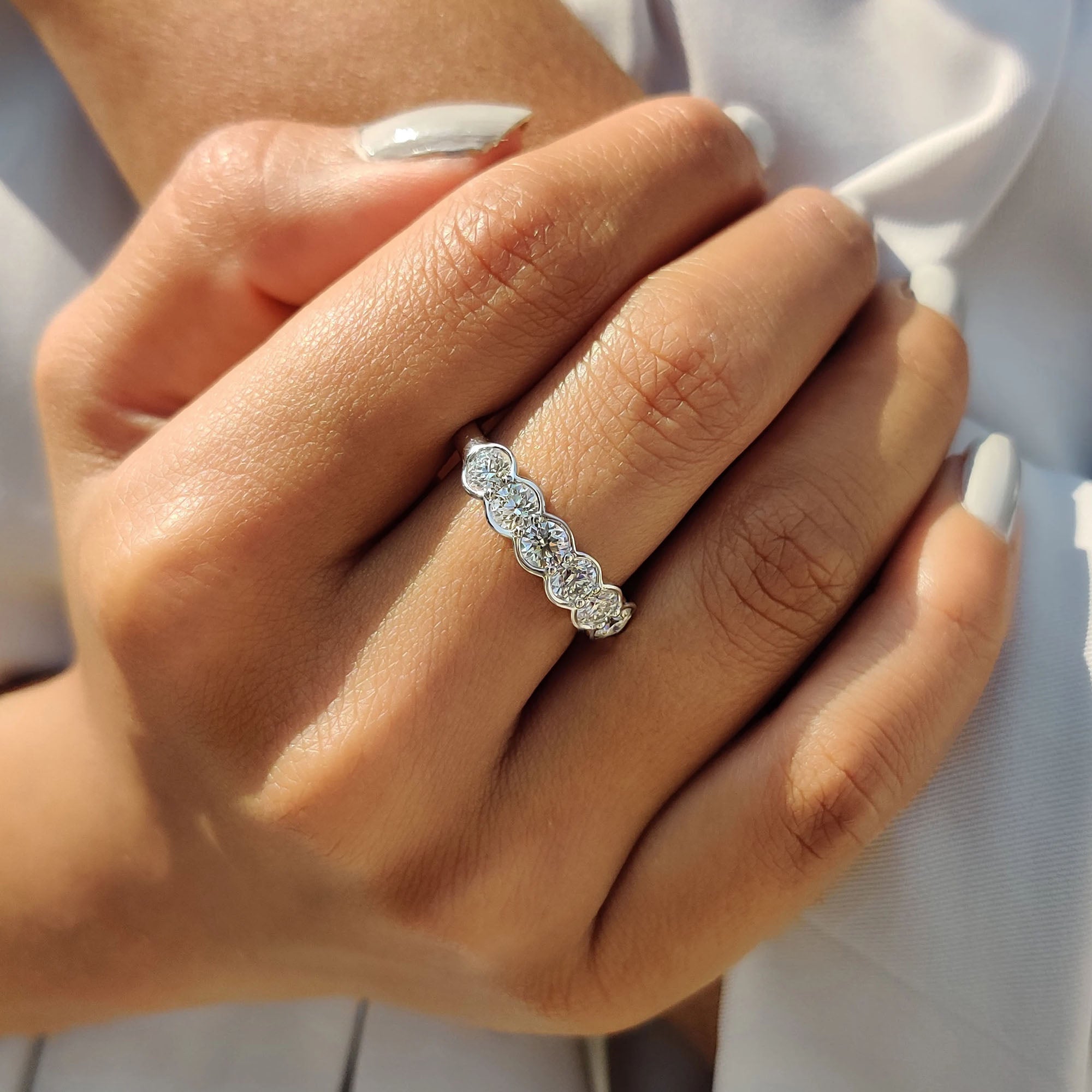 Half eternity band with moissanite stones set in polished white gold.
