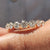 Shared prong wedding band with round cut moissanite in a full eternity layout.
