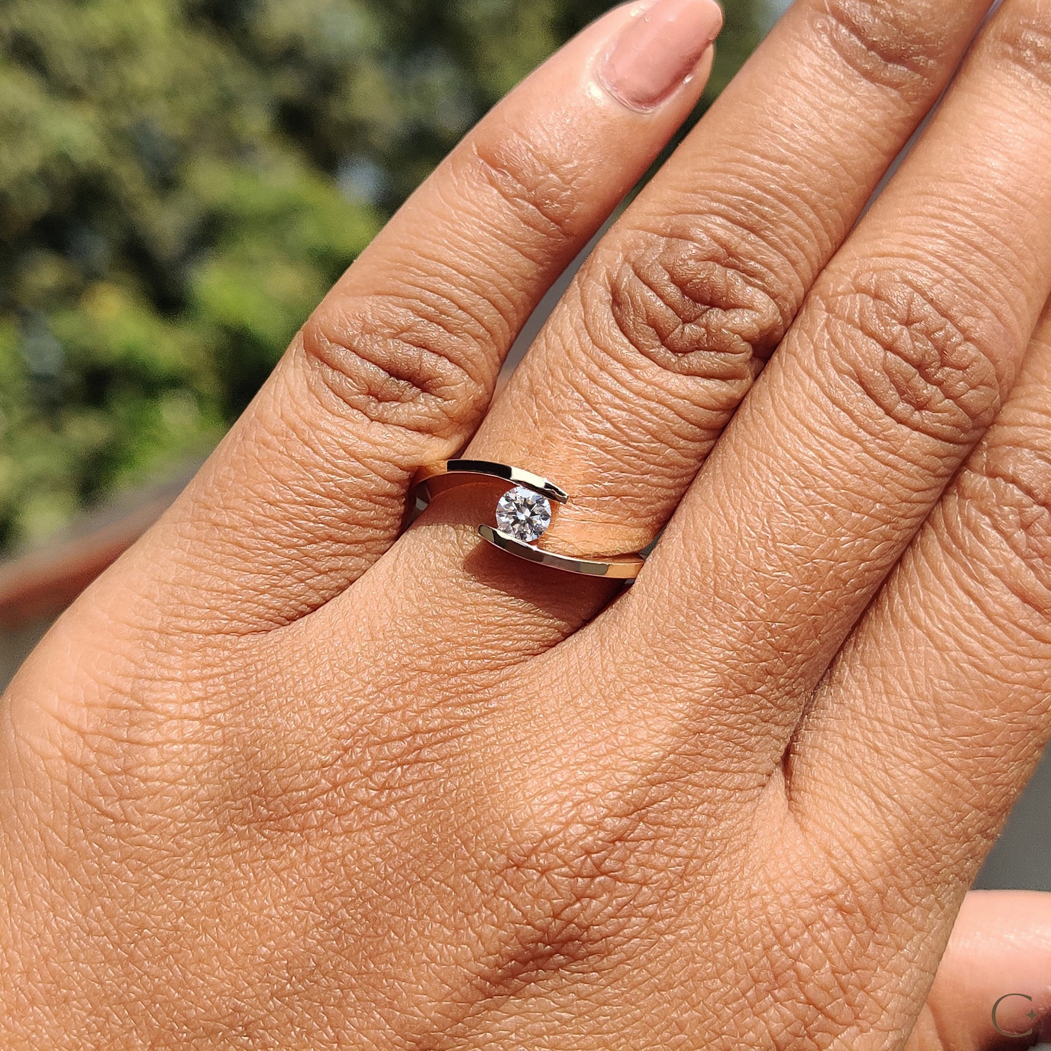 Round cut diamond ring sparkling in natural light.

