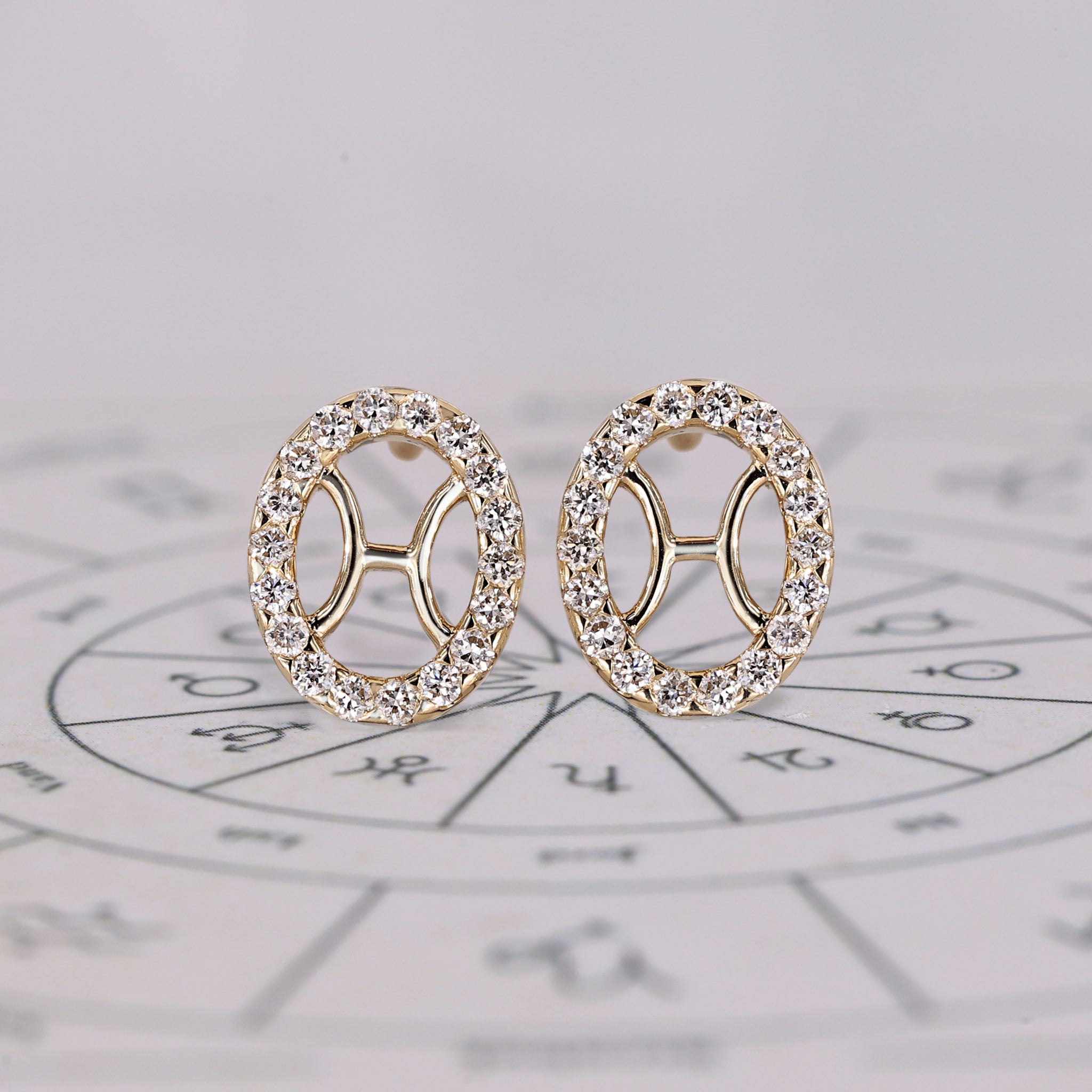 Pisces earrings in yellow gold with halo diamond studs.

