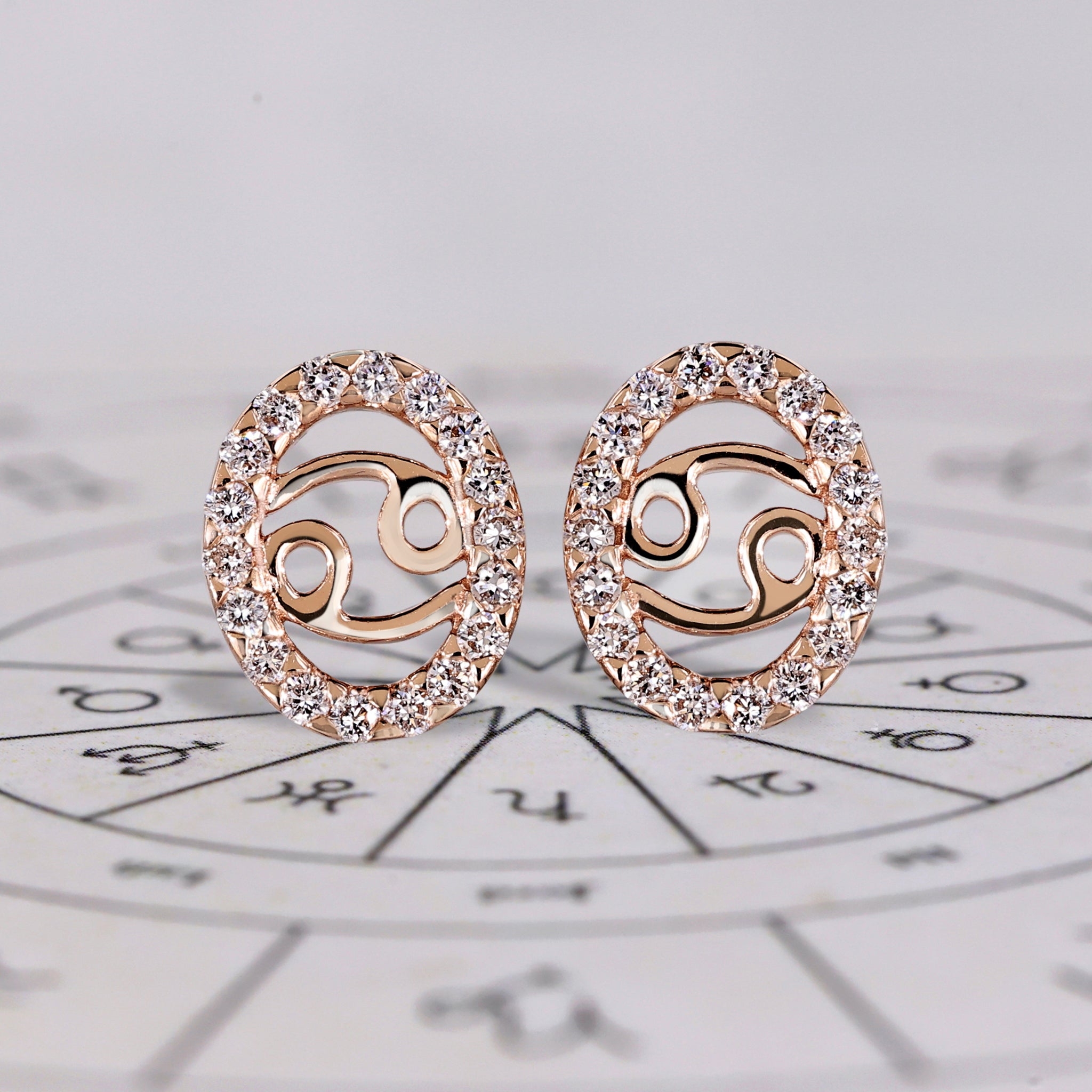 Cancer earrings in rose gold with round cut halo diamonds.
