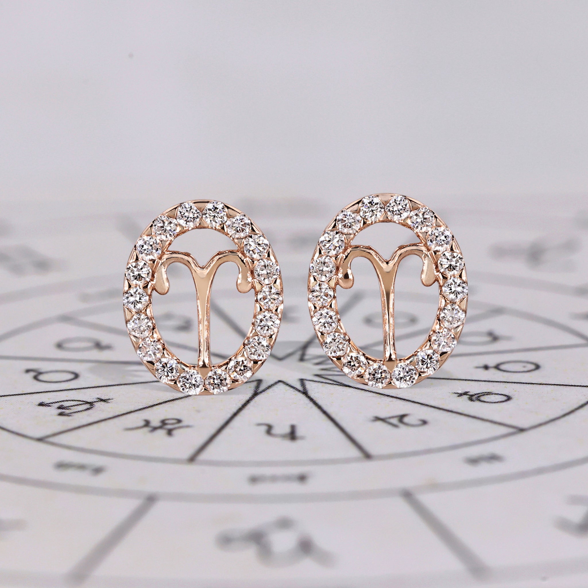 Aries earrings in rose gold with round cut halo diamonds.
