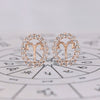 Aries earrings in rose gold with round cut halo diamonds.
