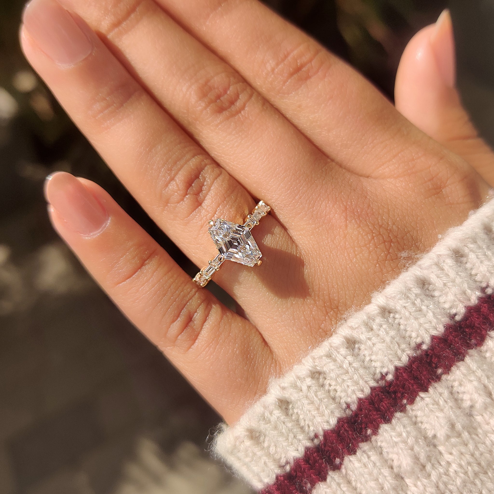 Elongated hexagon diamond ring with compass prong setting.
