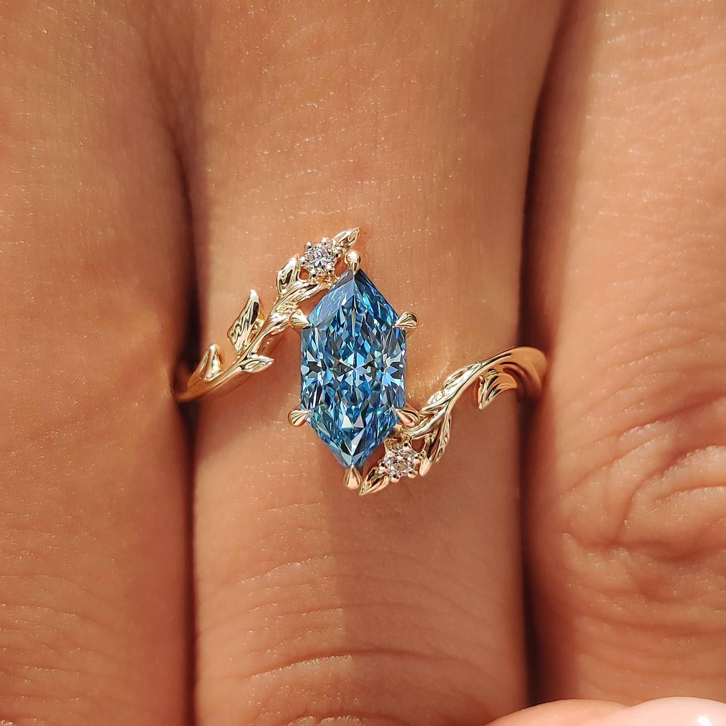 Blue Dutch marquise center diamond in a six claw prong setting.
