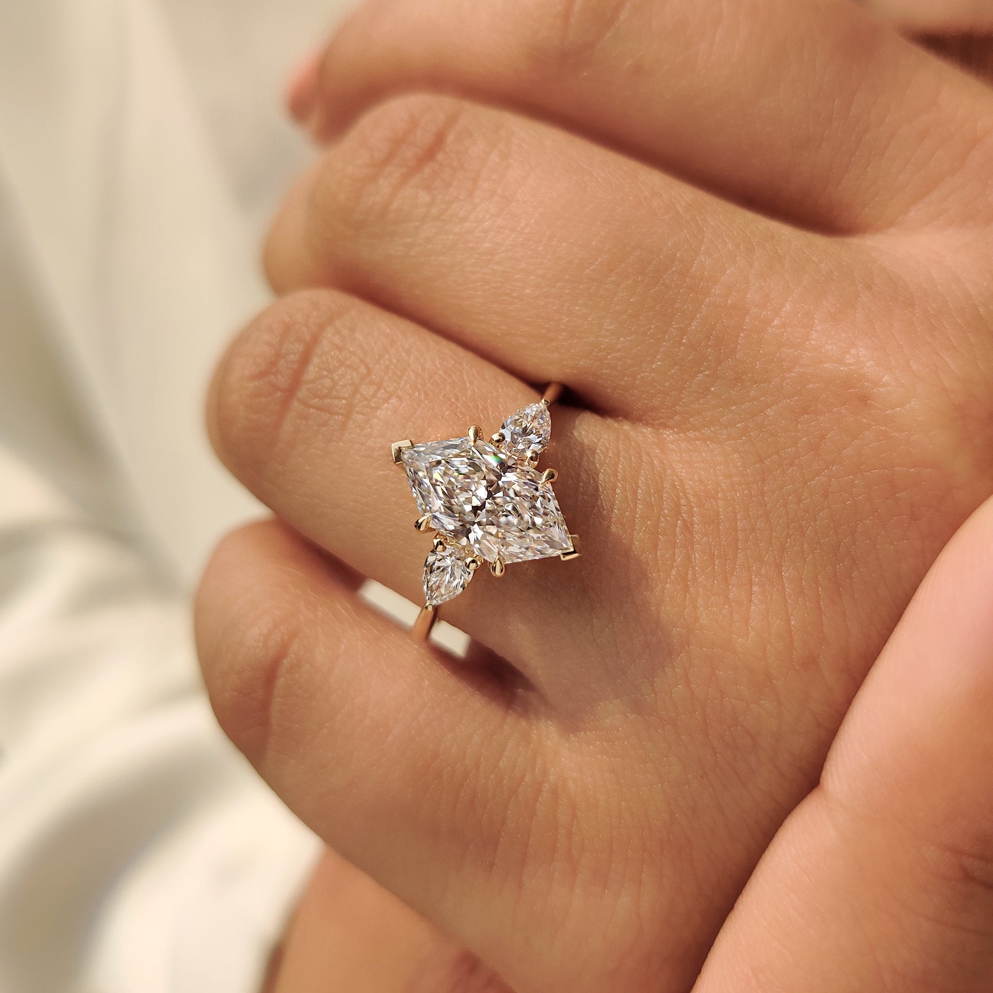 Three stone engagement ring with two V prong and four claw prong
