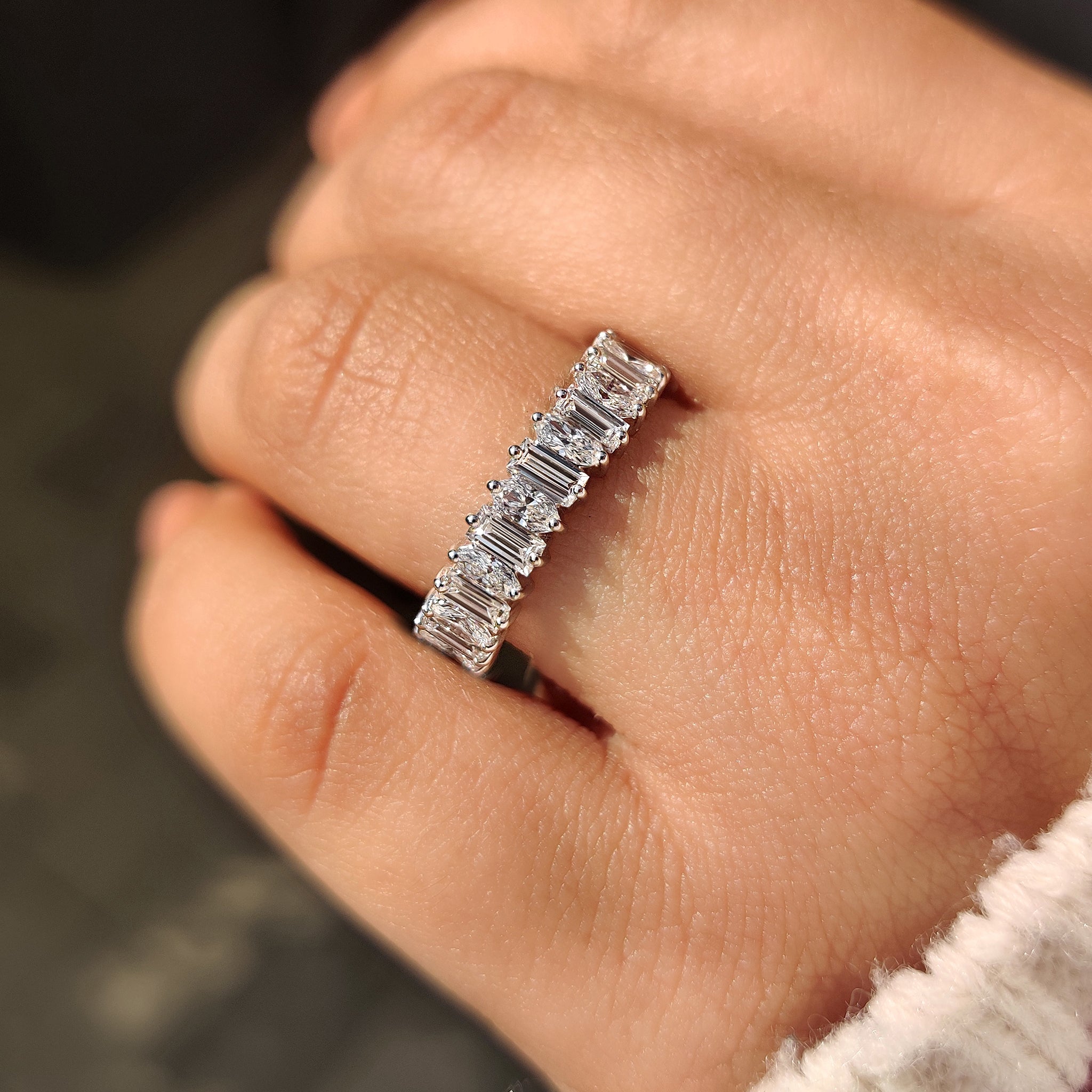 Half eternity wedding band featuring baguette and oval diamonds

