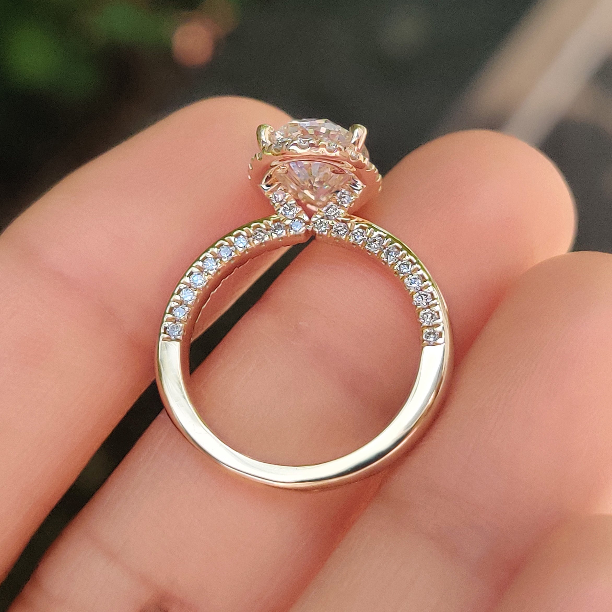 Four prong basket secures oval cut diamond ring with pave band.
