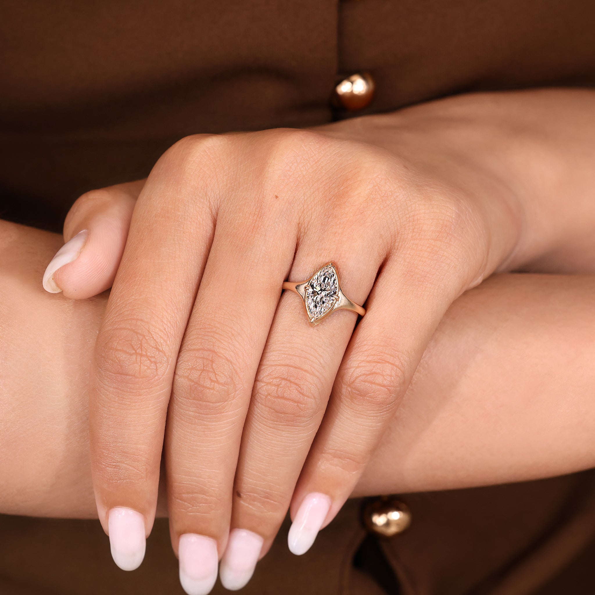 Solitaire setting marquise diamond ring with bezel design.
