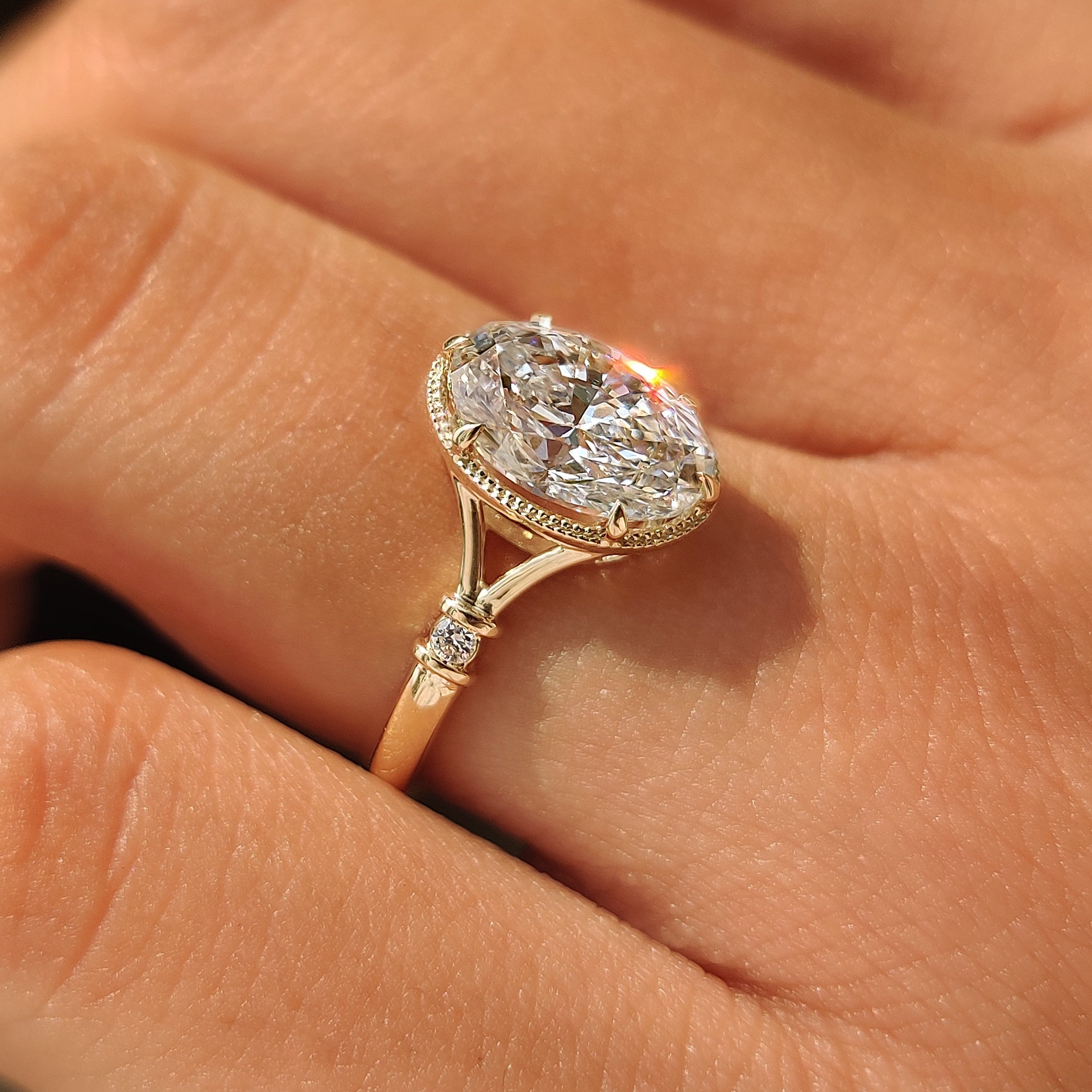 Lab grown oval diamond engagement ring with milgrain edges.
