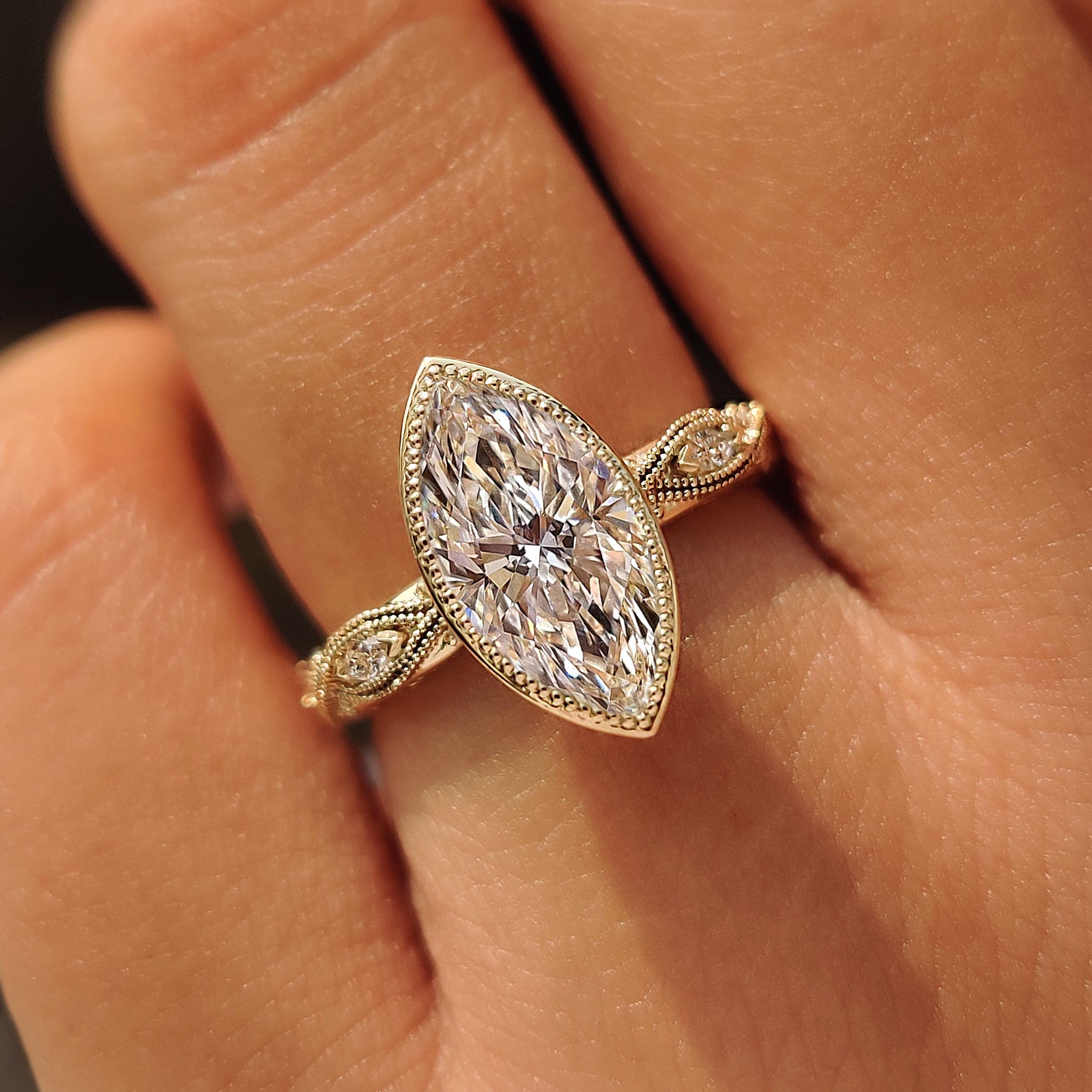 Lab grown marquise center diamond with milgrain bezel setting.
