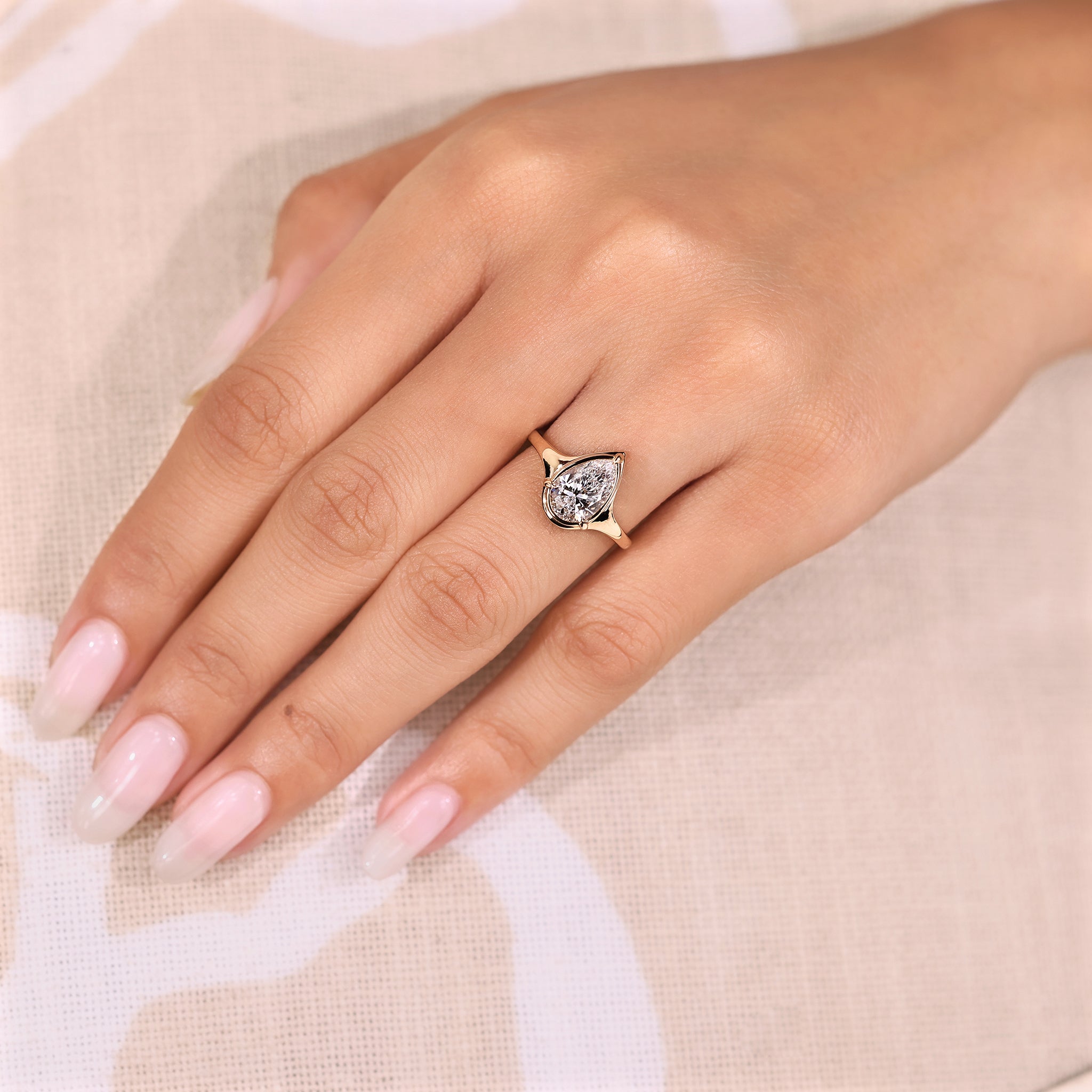 Solitaire pear cut diamond ring with three claw prong.
