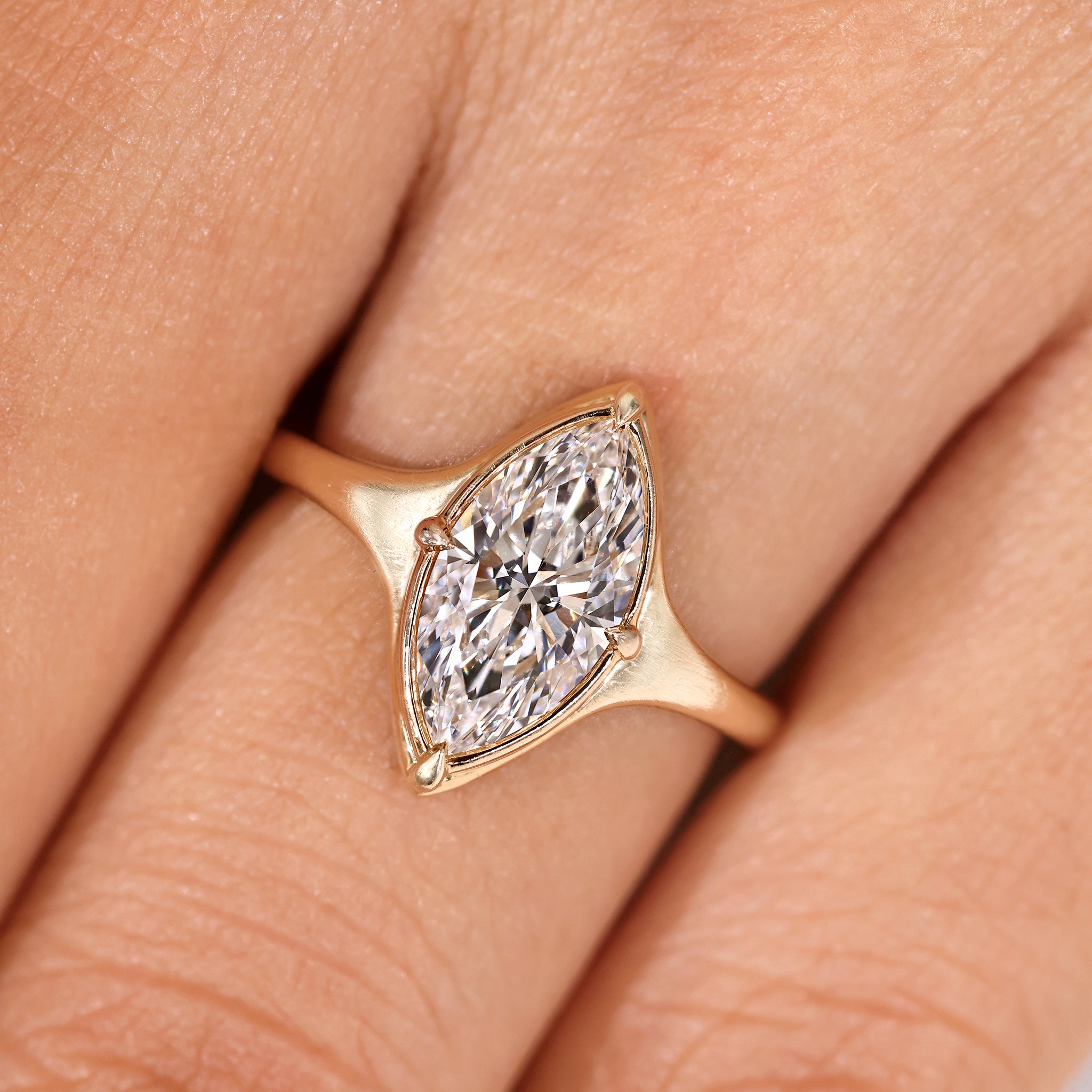 Marquise diamond engagement ring with tapered shank band.
