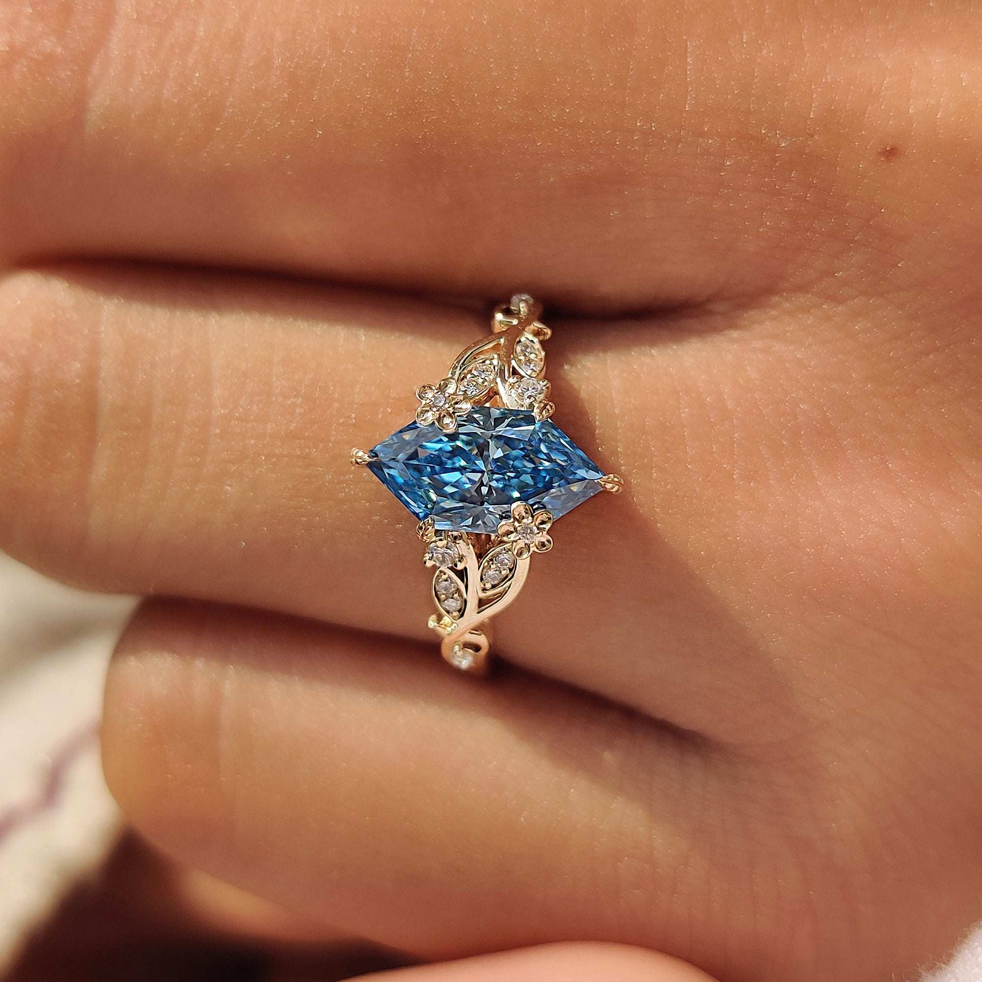 Leaf style prongs securing the blue center diamond.
