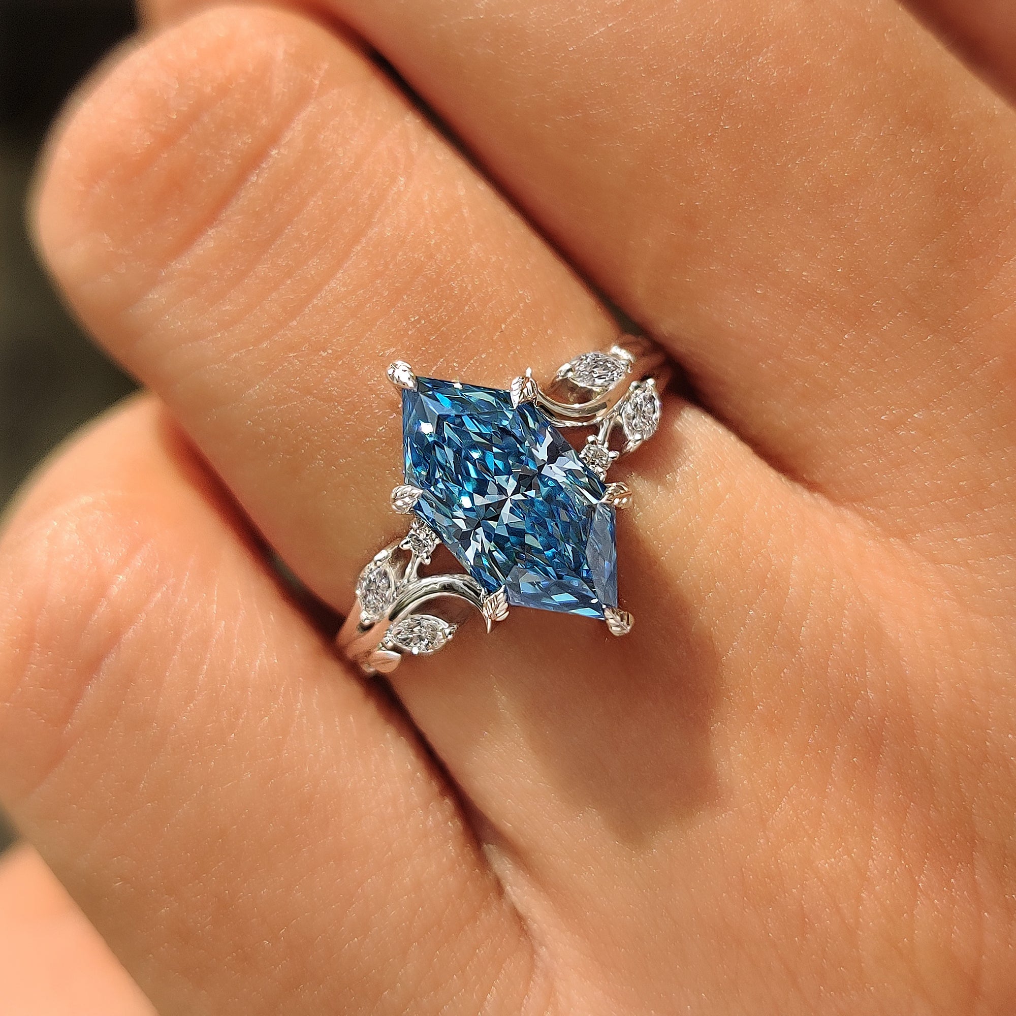 Six leaf style prongs securing the center blue Dutch marquise diamond.

