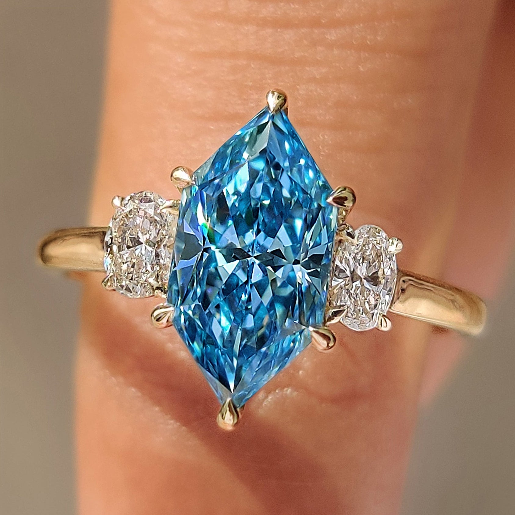 Blue Dutch marquise trilogy engagement ring with oval side stones.

