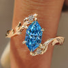 Blue Dutch marquise diamond ring with bypass vine shank in yellow gold.
