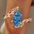 Blue Dutch marquise diamond ring with bypass vine shank in yellow gold.

